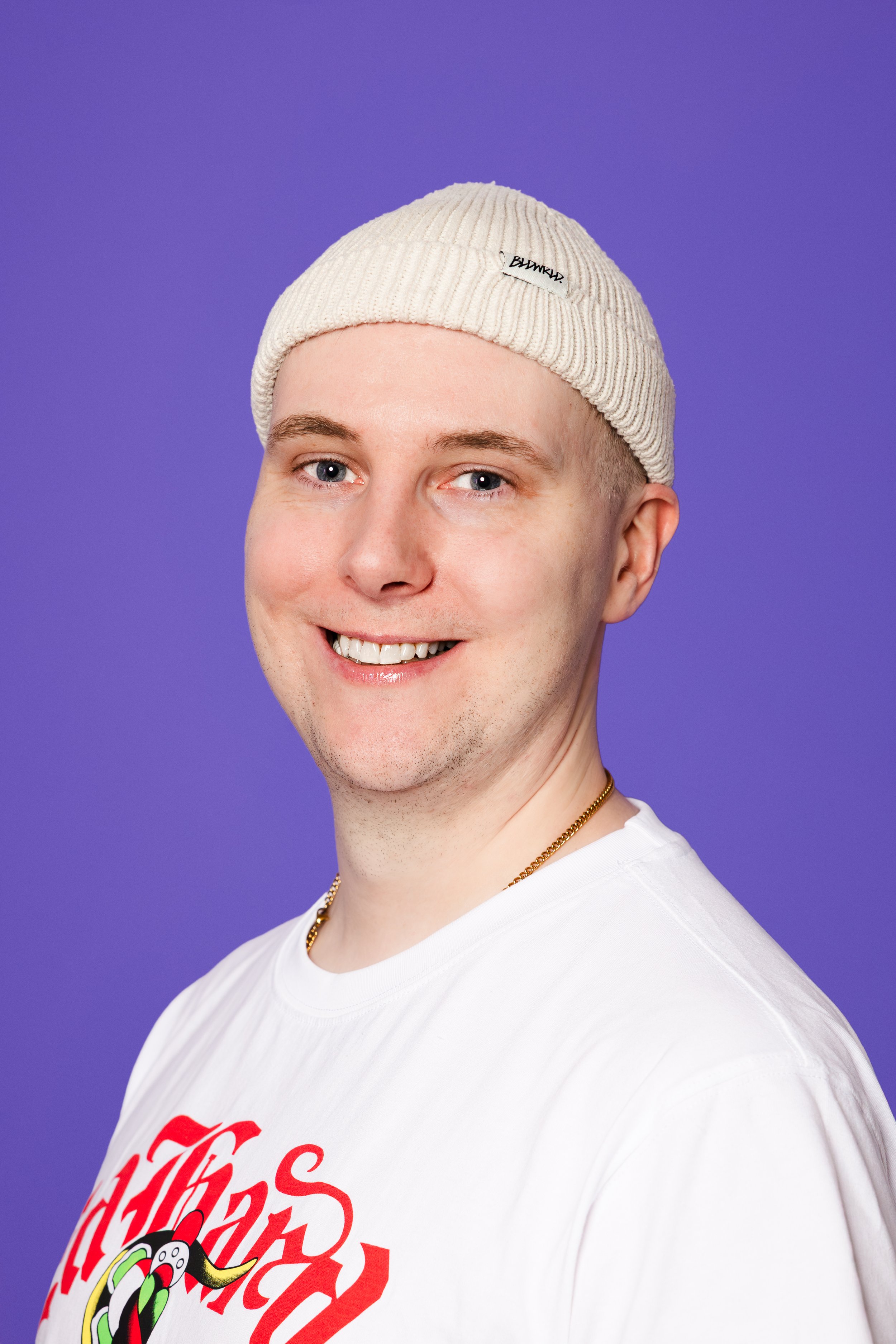 Guðni Freyr Öfjörð brosir í hvítum bol með hvíta húfu og keðju um háls