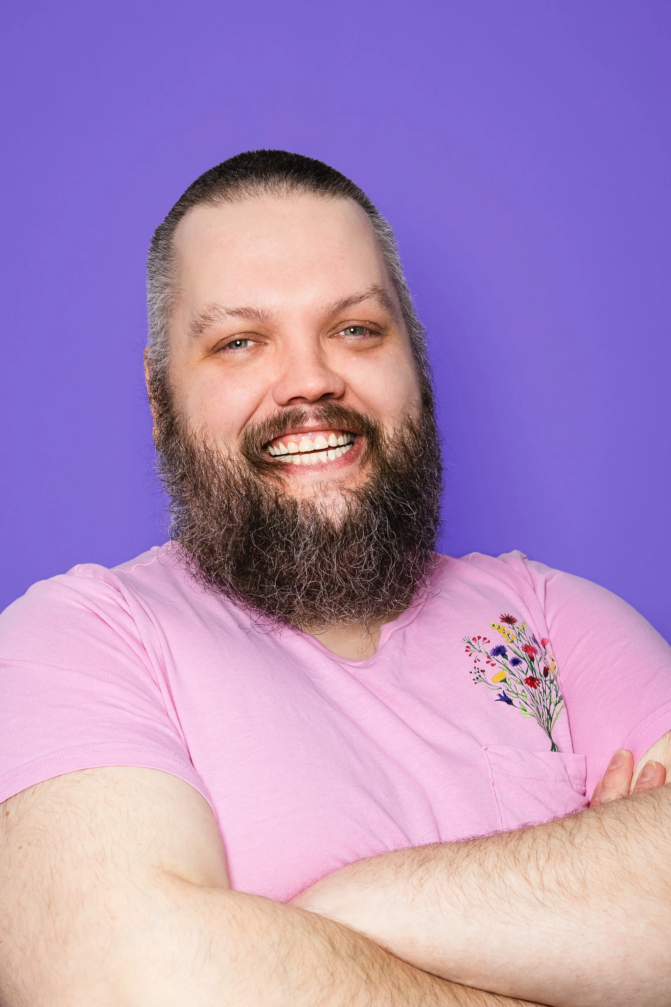 Oddur brosir í bleikum bol, hann er með stutt hár og mikið skegg