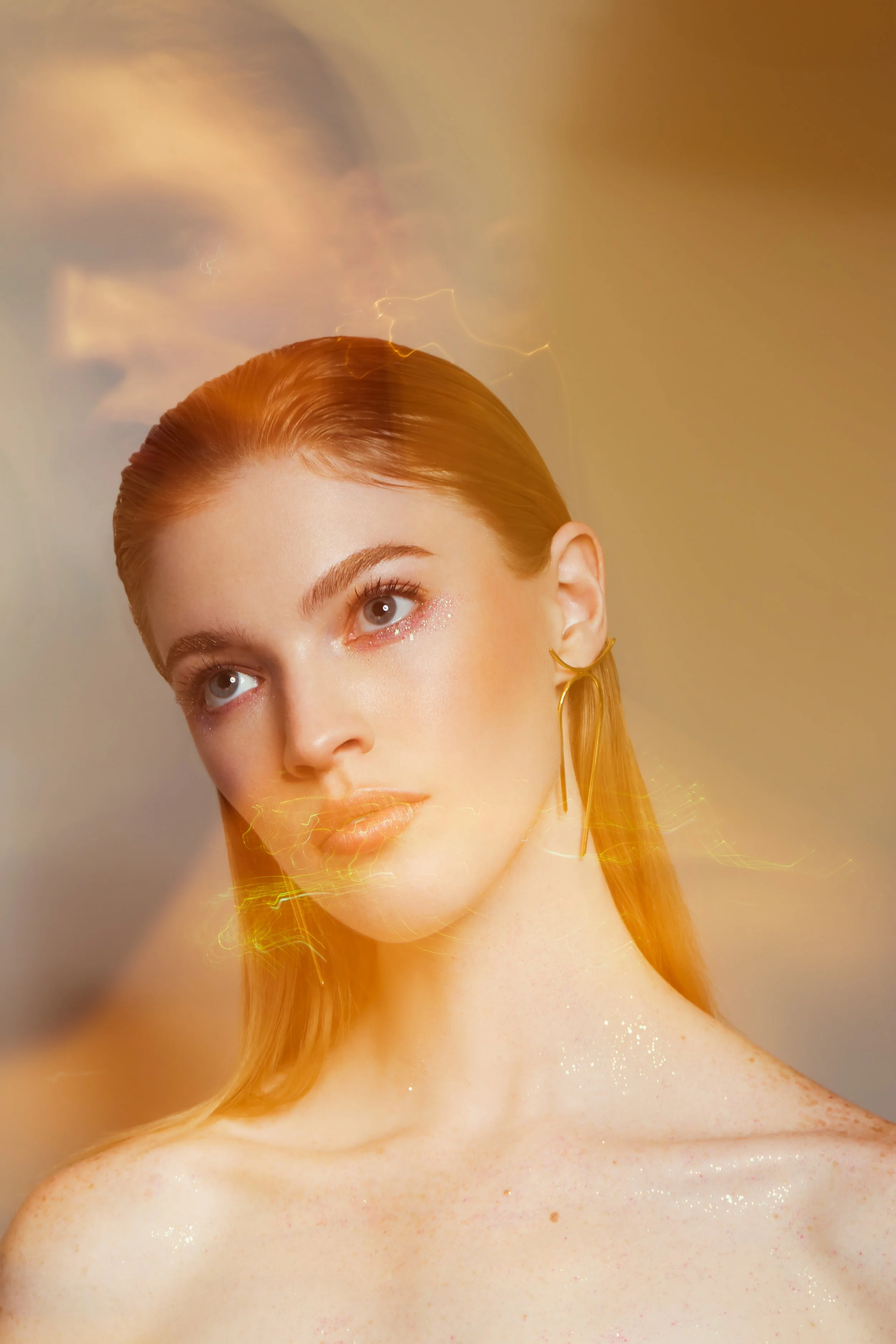 A woman with red hair and gold earrings looking thoughtfully, with a soft focus portrait overlay of her face.