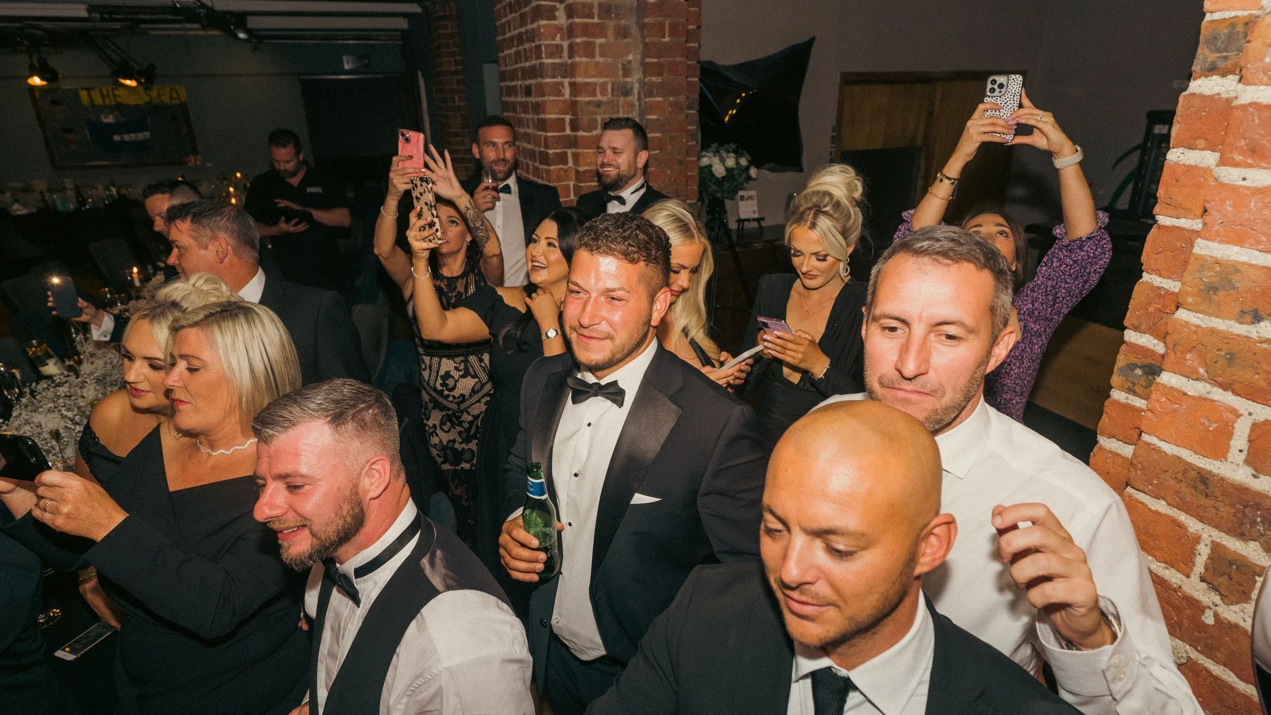 People at a formal event taking photos and enjoying themselves.