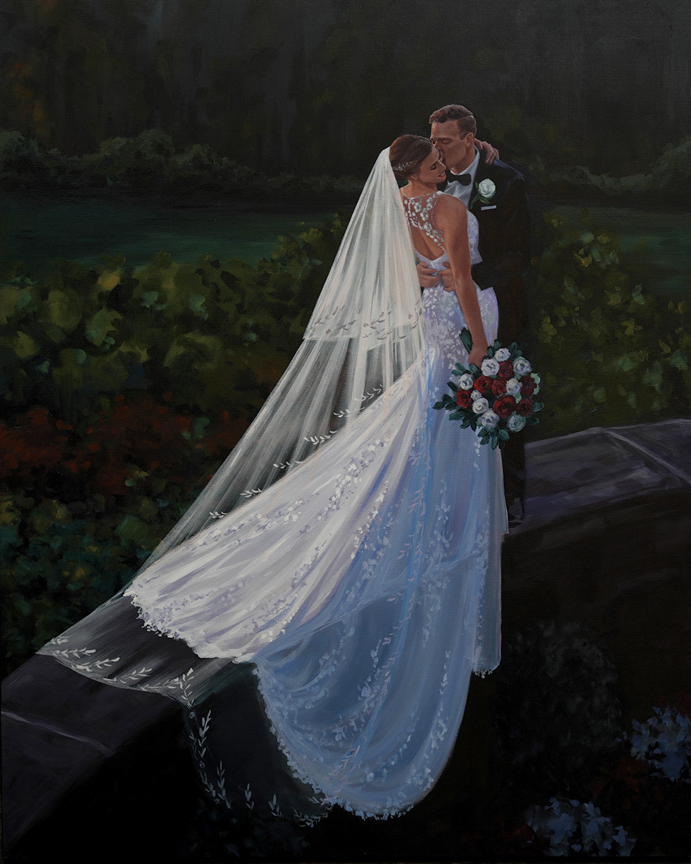 A bride and groom sharing a kiss outside on a stone ledge, with the bride holding a bouquet of red and white roses. The bride wears a long white gown with a lace back and a veil, and the groom is dressed in a black tuxedo with a bowtie and boutonnier