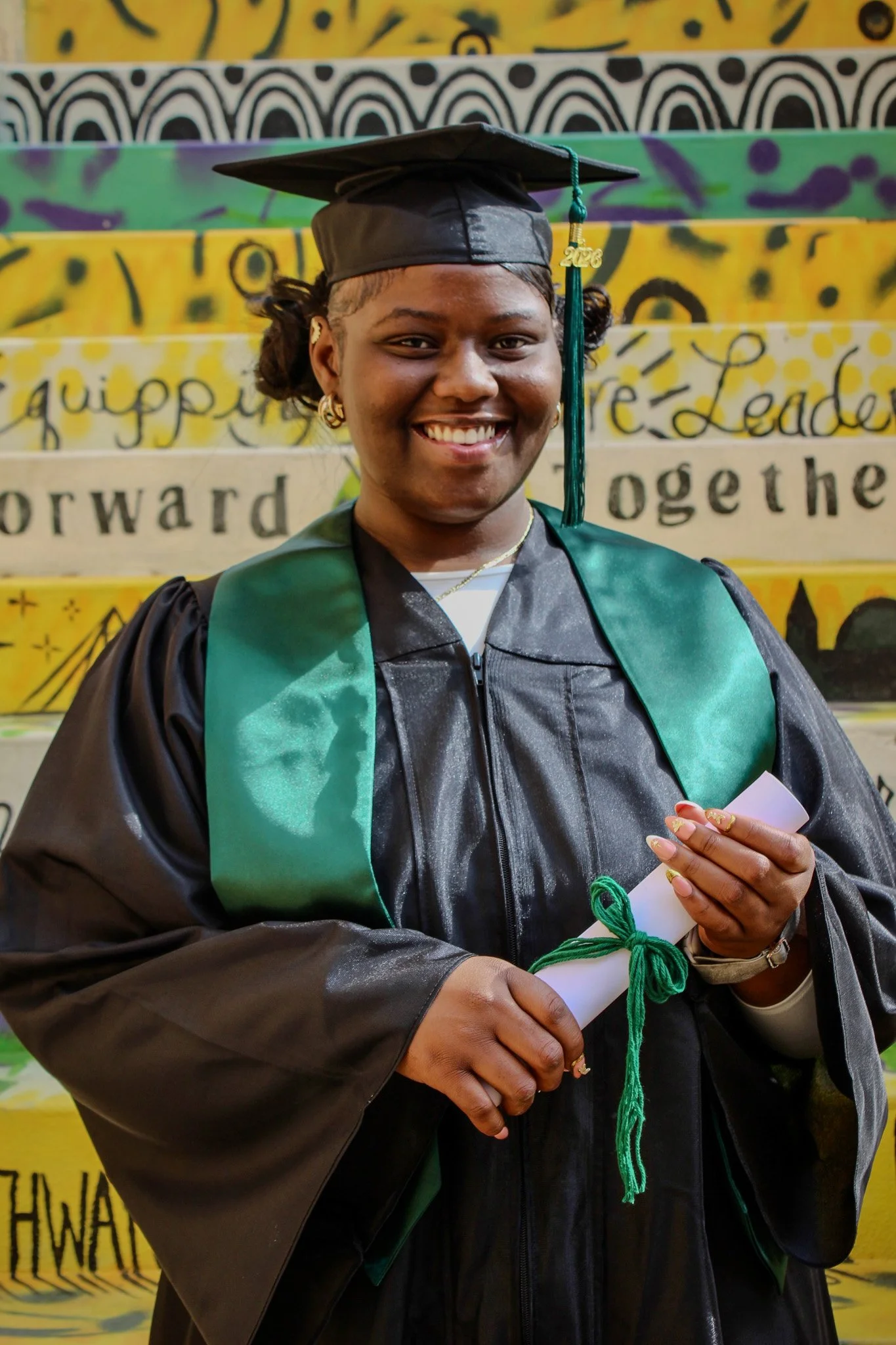 Female graduate smiling wearing cap and gown
