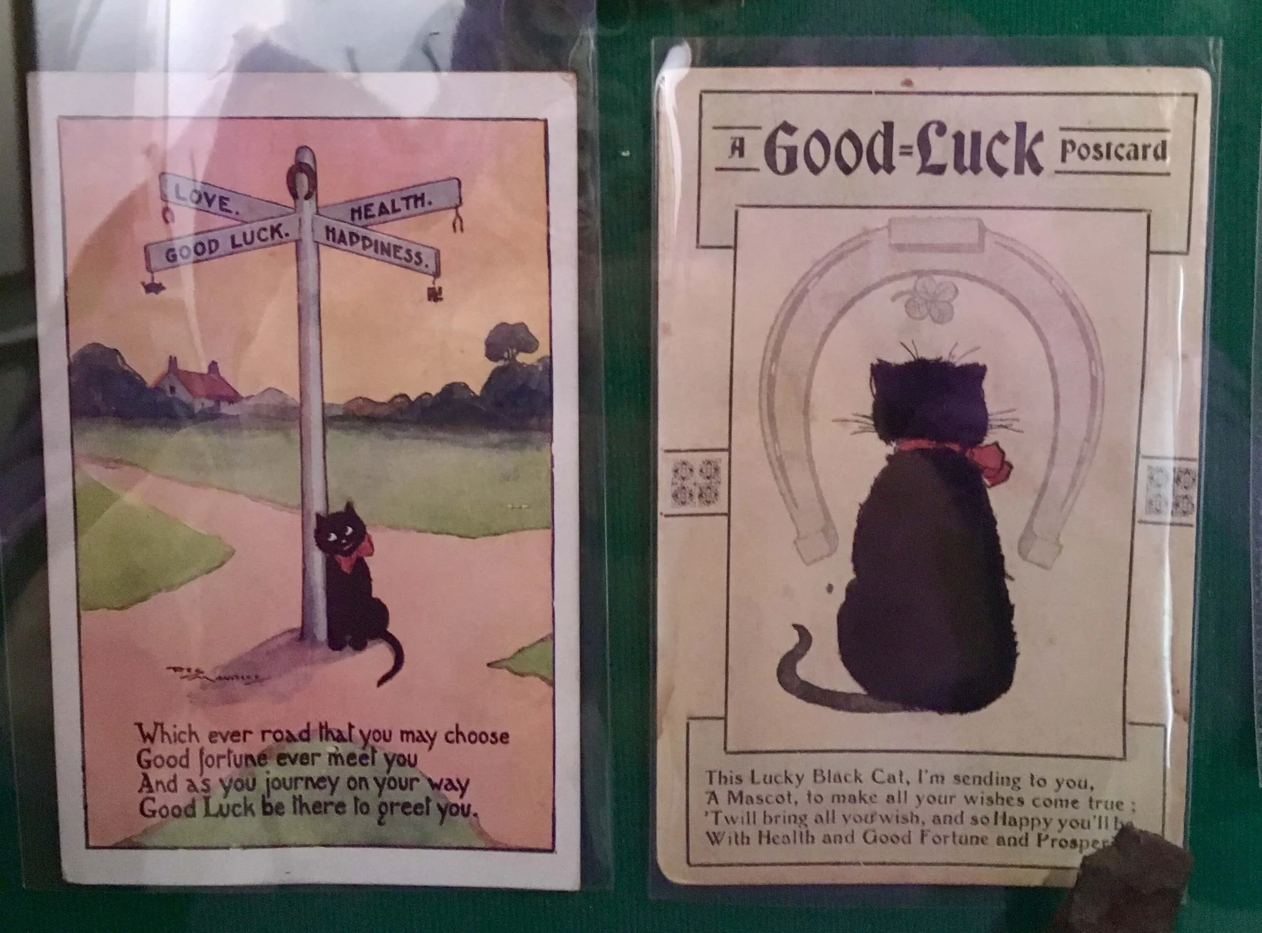 Two vintage postcards featuring black cats symbolizing good luck and happiness.