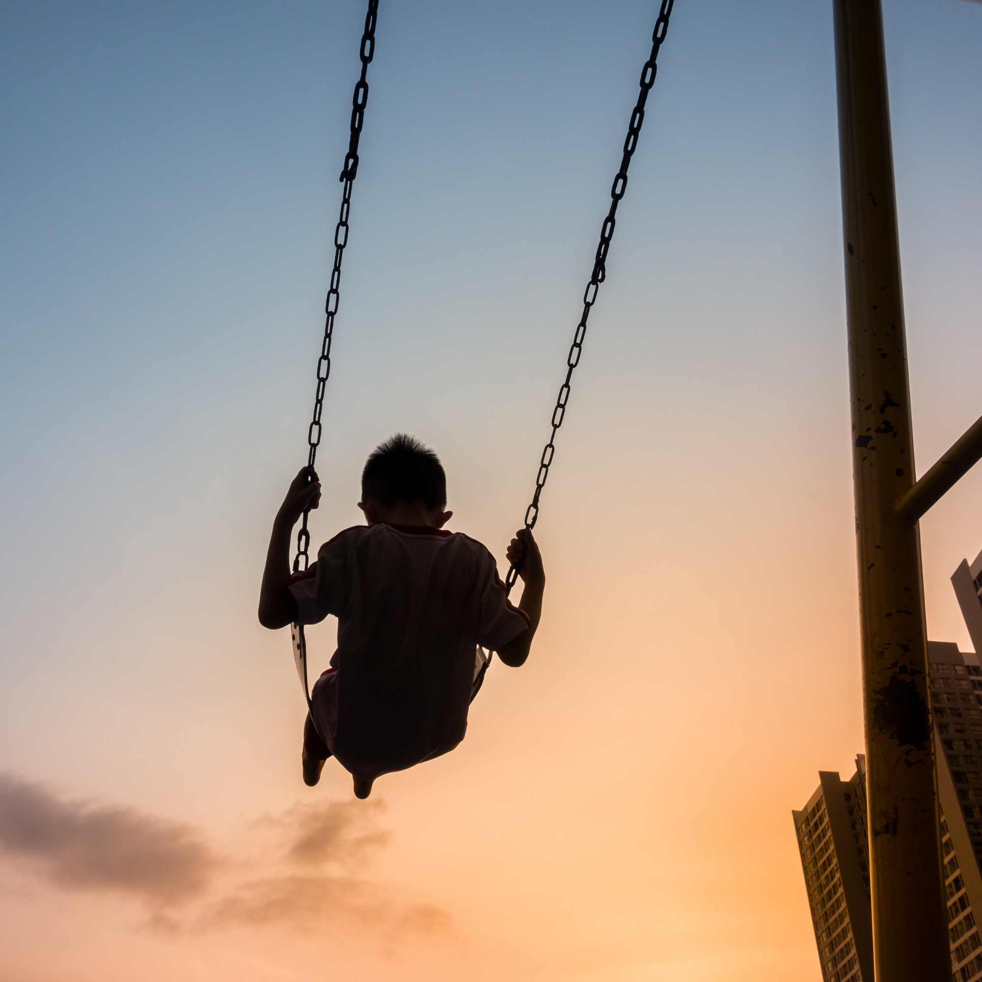 Image of young boy swinging in Walnut Street Playground to illustrate parentification trauma therapy in New Orleans, LA, Colchester, Connecticut and Falls Church, Virginia