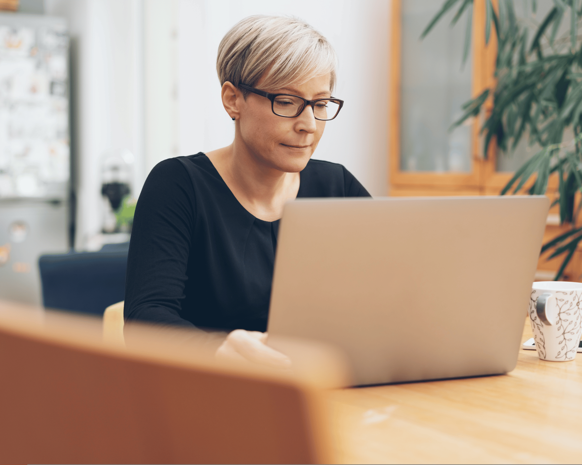 Image of adult woman sitting on computer to illustrate what is parentification trauma and online therapy for parentification trauma in Falls Church, Virginia