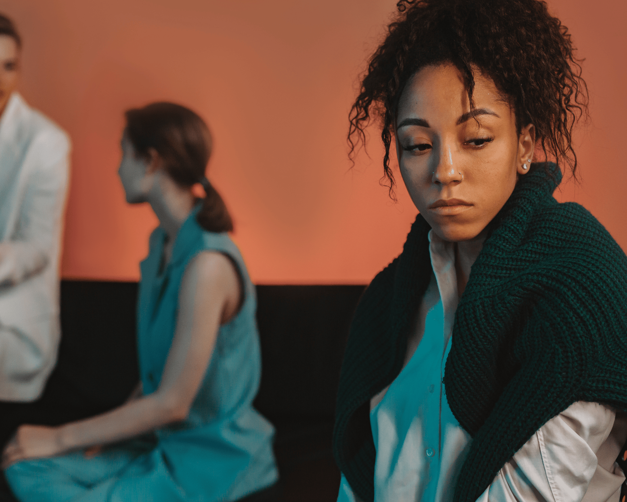 Image of sad adult woman being left out by other adult women to illustrate parentification trauma therapy in New Orleans, LA, Colchester, CT and Falls Church, VA