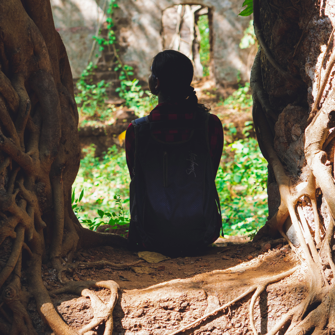 Image of woman sitting on shaded tree roots to illustrate roots of intergenerational trauma & parentification trauma therapy in Colchester, CT 06415 & Virginia