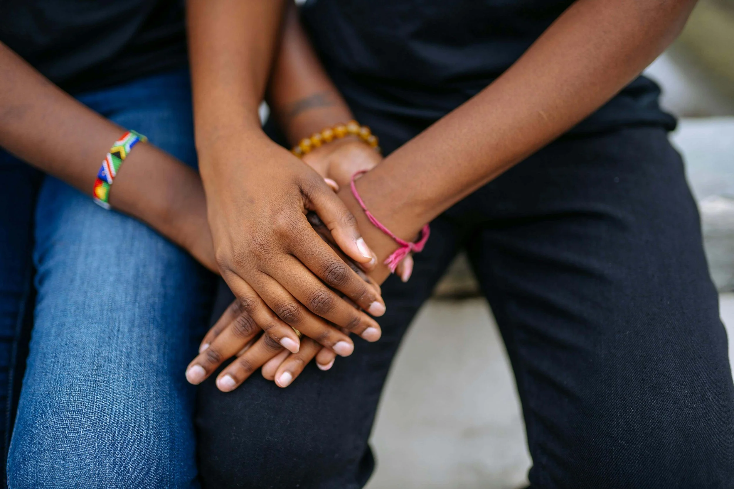 Close-up of two people holding hands, symbolizing safety, trust, and repair supported through therapy for healing attachment wounds in Falls Church, VA.