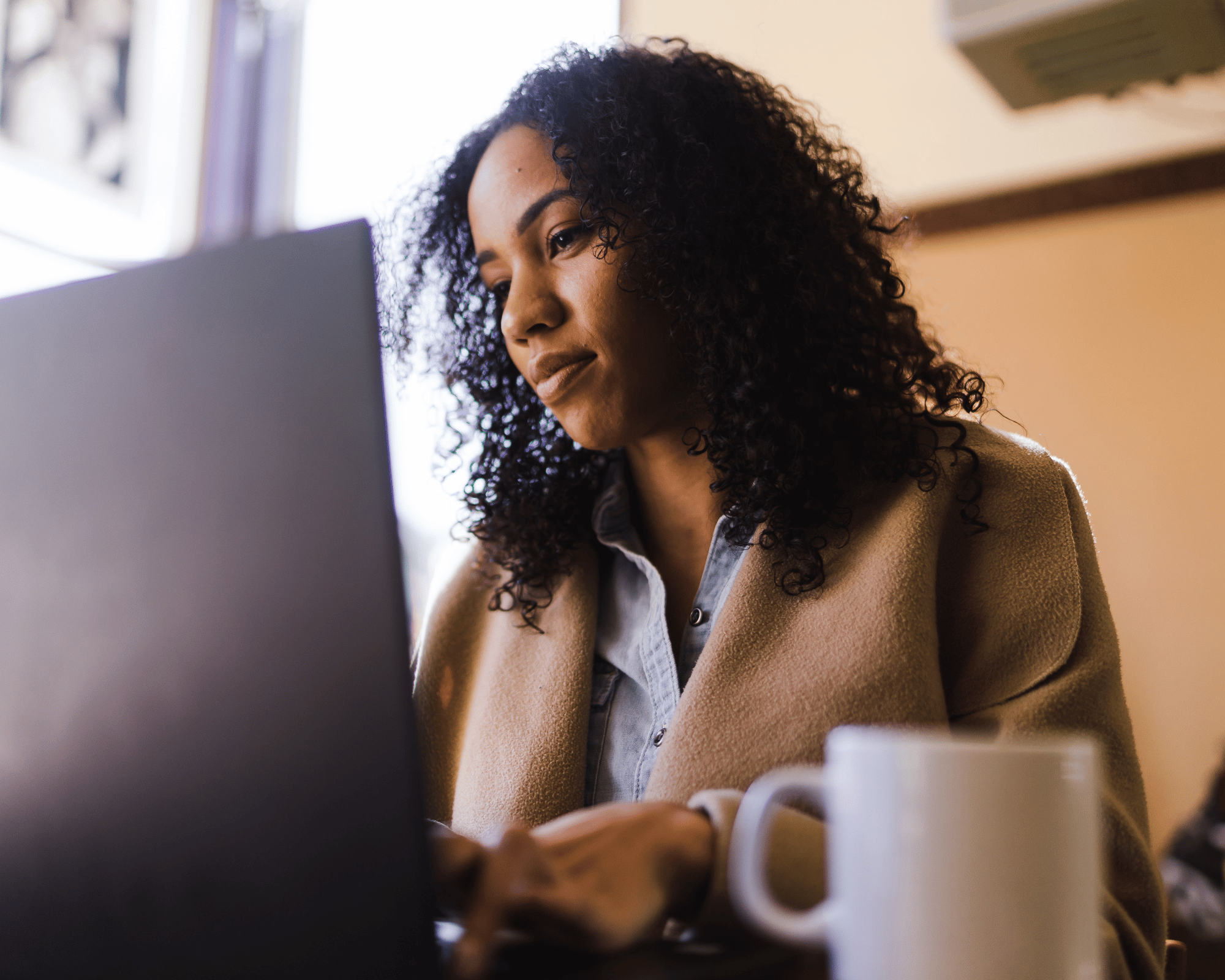 Image of adult woman on computer to illustrate what is parentification trauma and online therapy for parentification trauma in Colchester, Connecticut