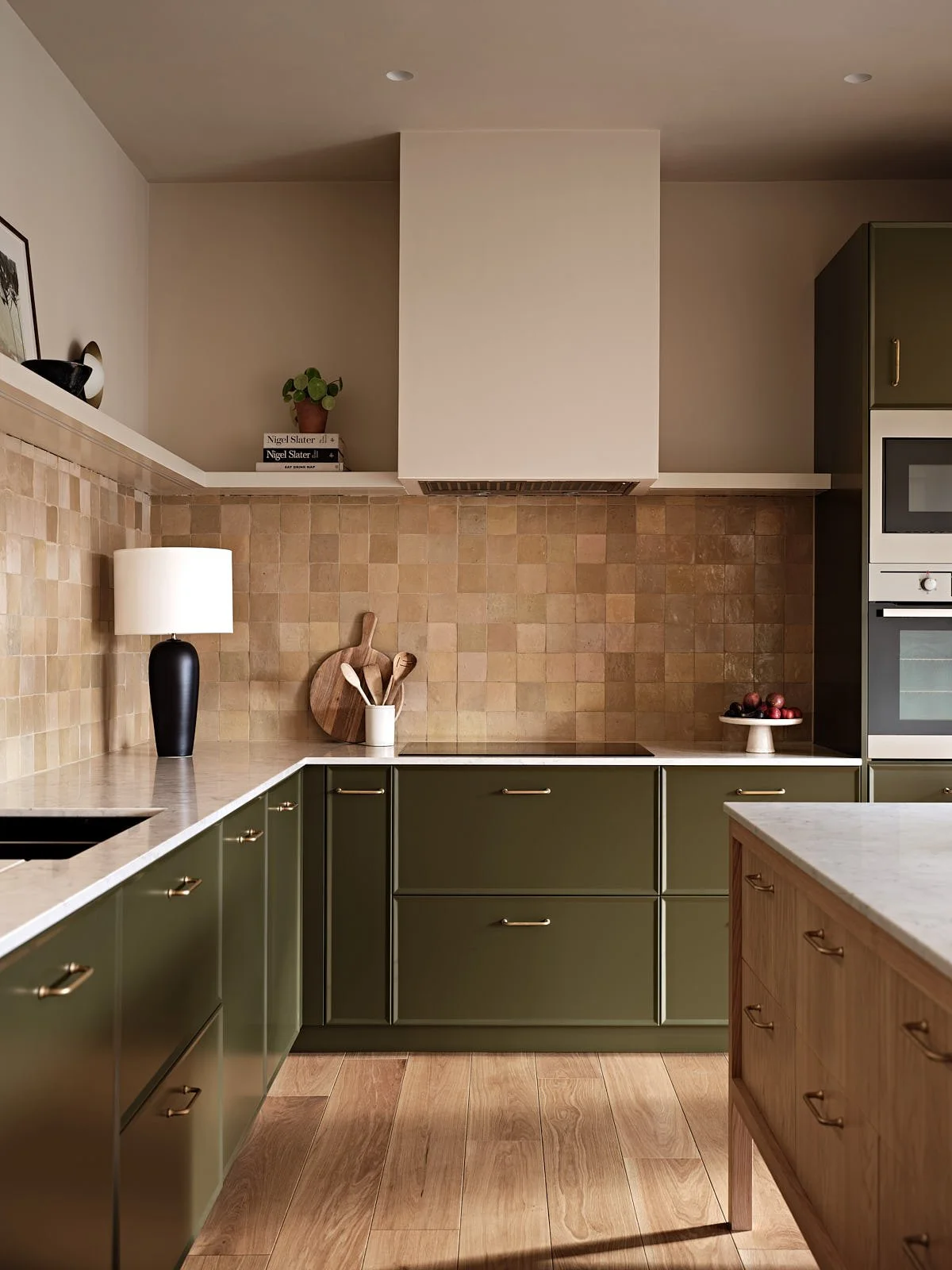 Green kitchen with island in a London family home designed by Studio Eight Design.