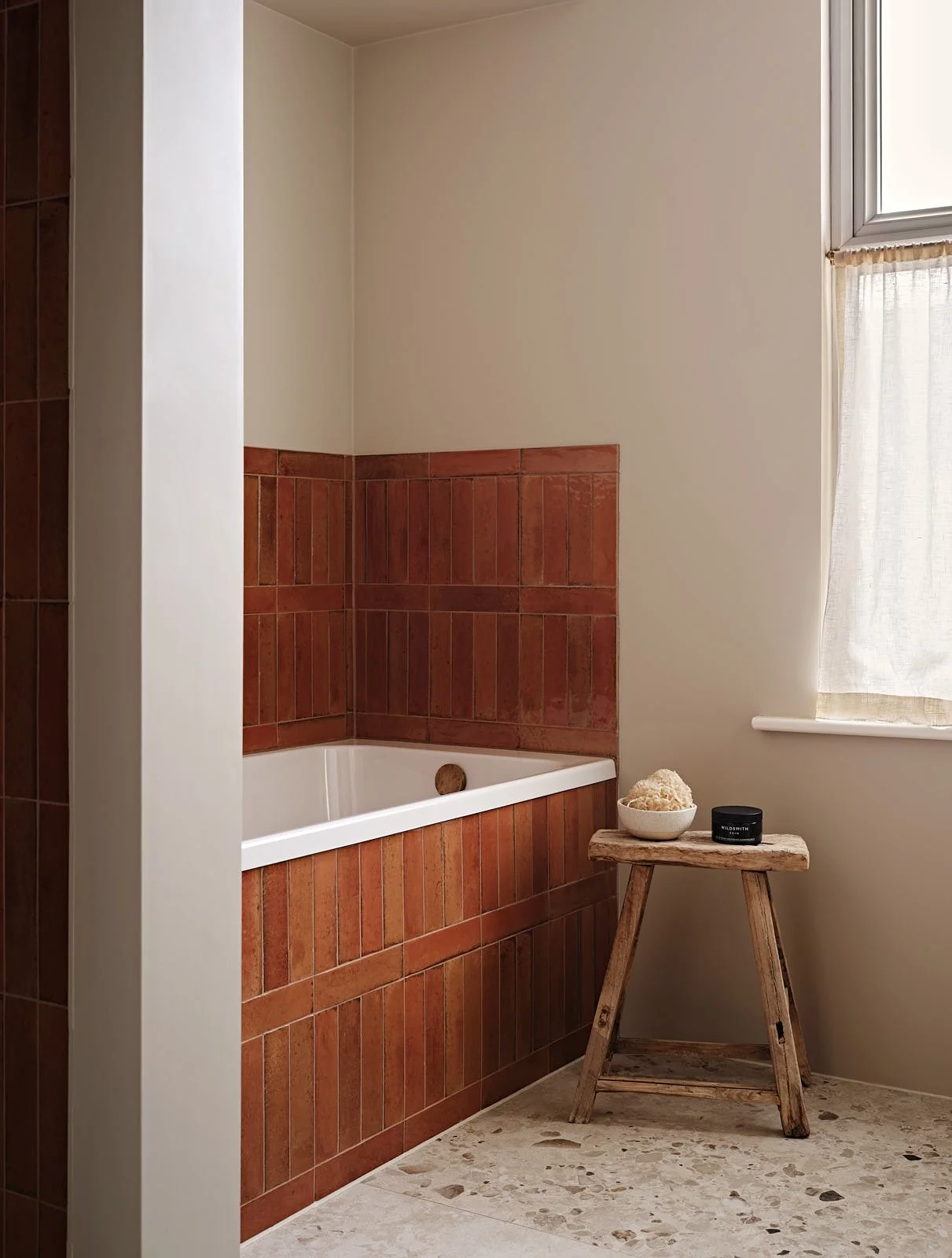 Orange tiled bath in a London family bathroom, designed by Studio Eight Design.