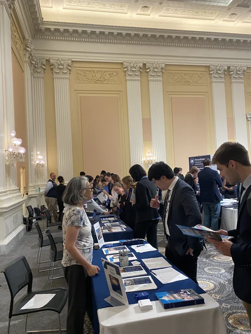 Grad fair attendees browsing tables in a Capitol Hill hall