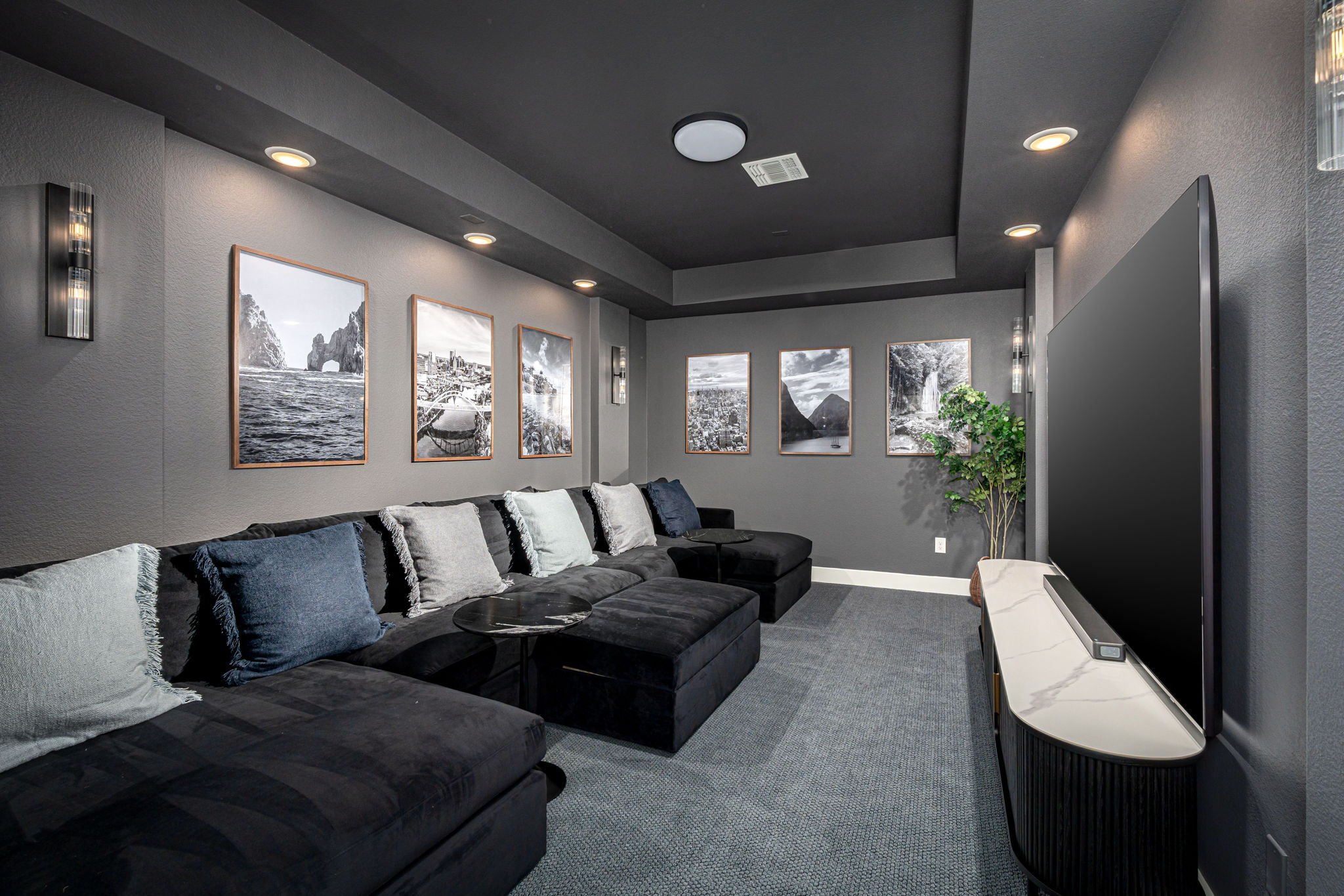Dark gray media room with travel posters on walls