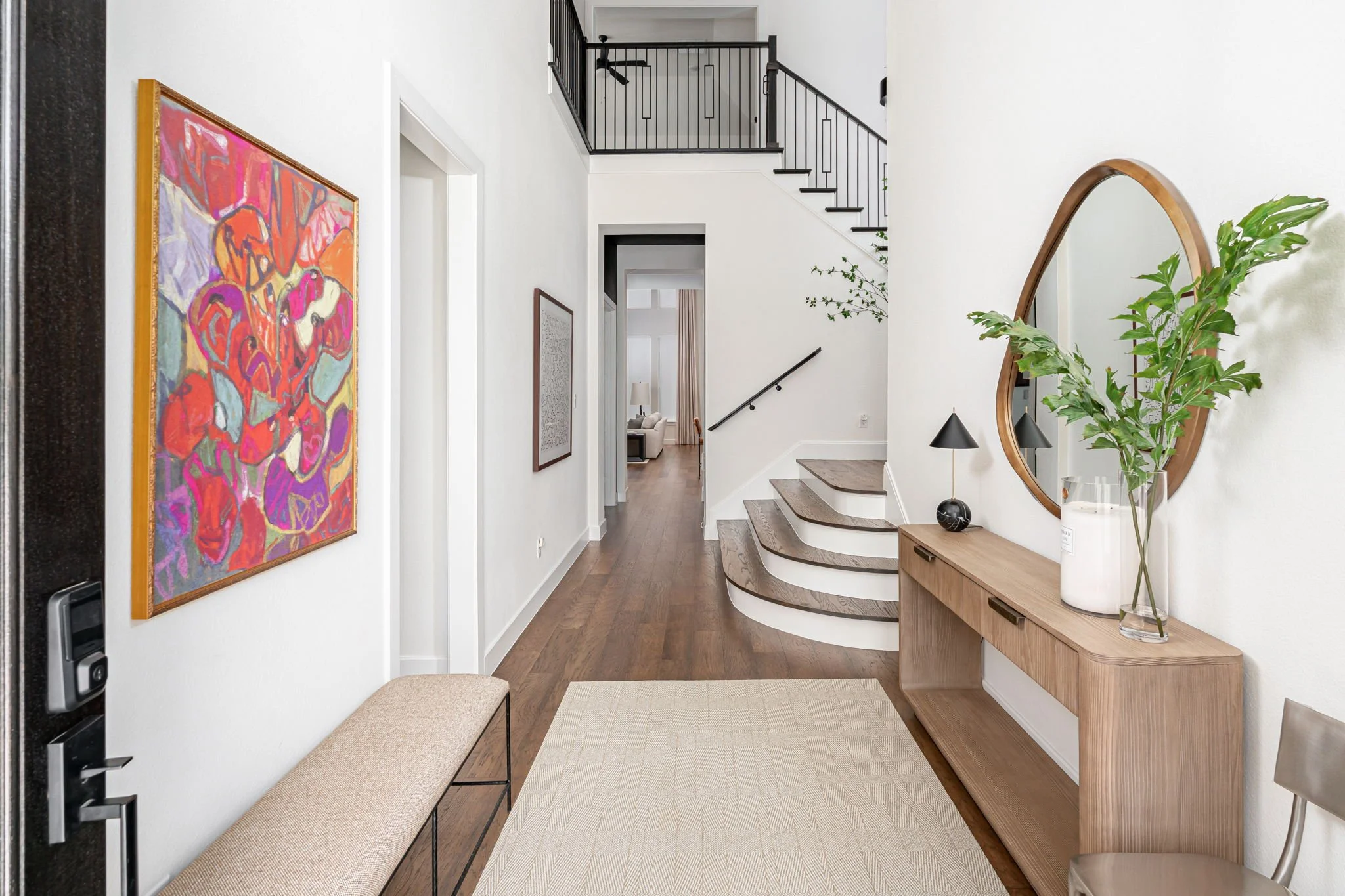 Entry in new home in prosper texas with white walls and neutral furnishings with bright abstract art