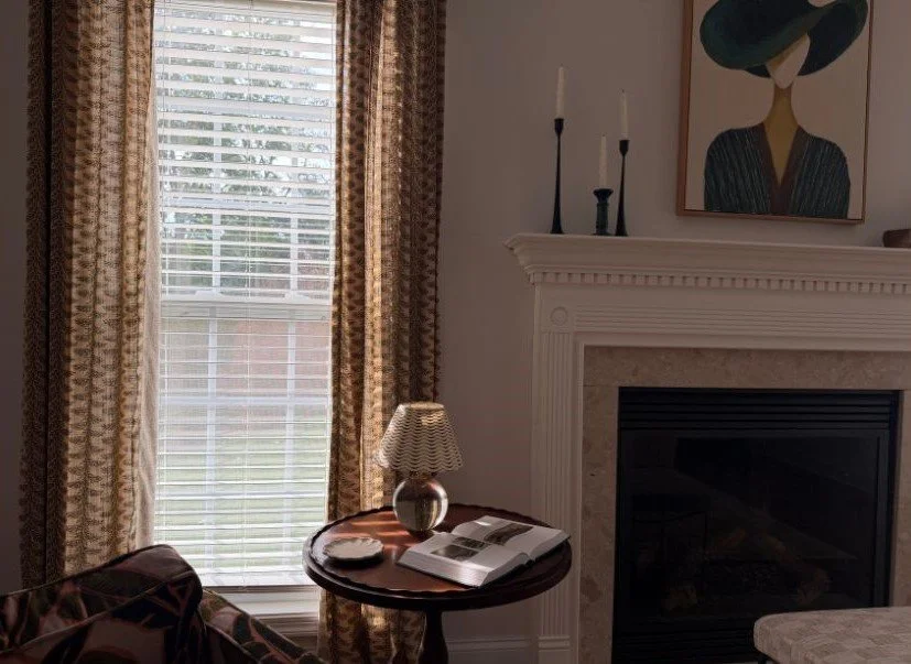 yellow and pink patterned drapes next to fireplace with green and yellow painting above