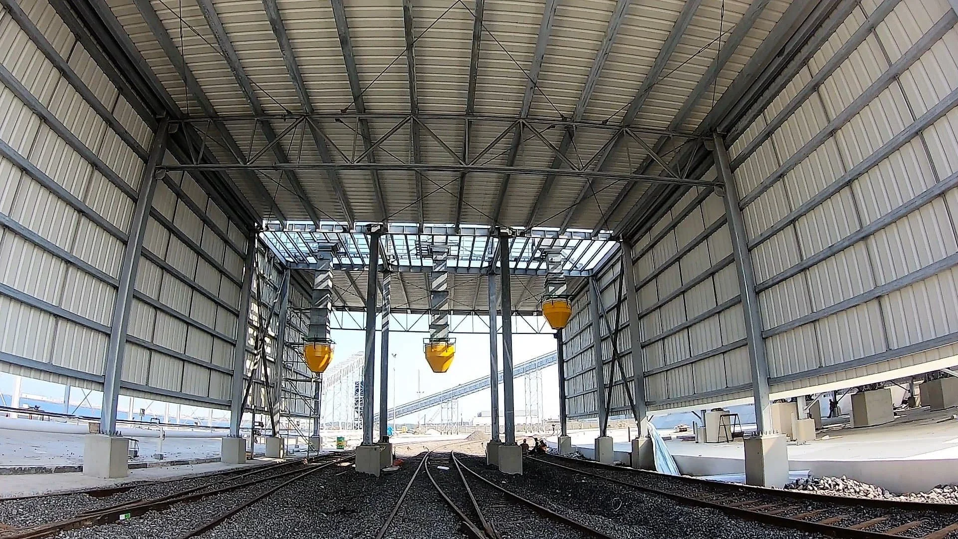 View inside a large train  facility with railway tracks, and dust suppression hoppers.