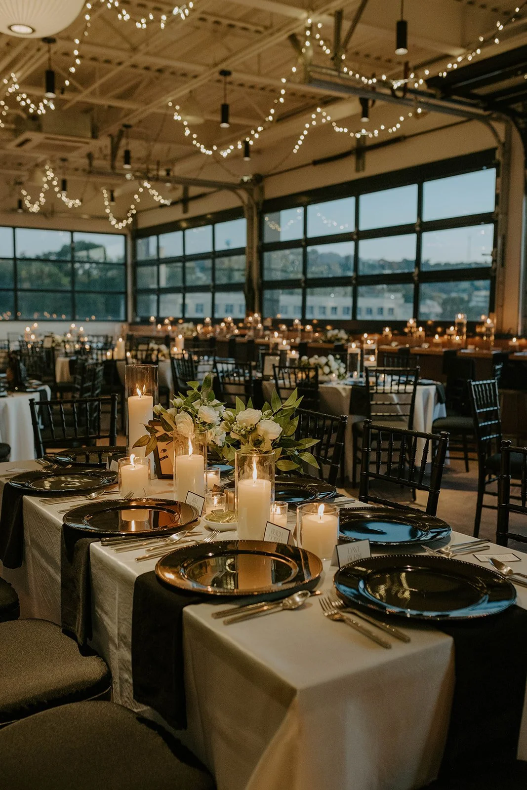 Detailed shot of the reception room as the day changes to night; highlights the string lights, candles, and ambiance of Over Eden. 