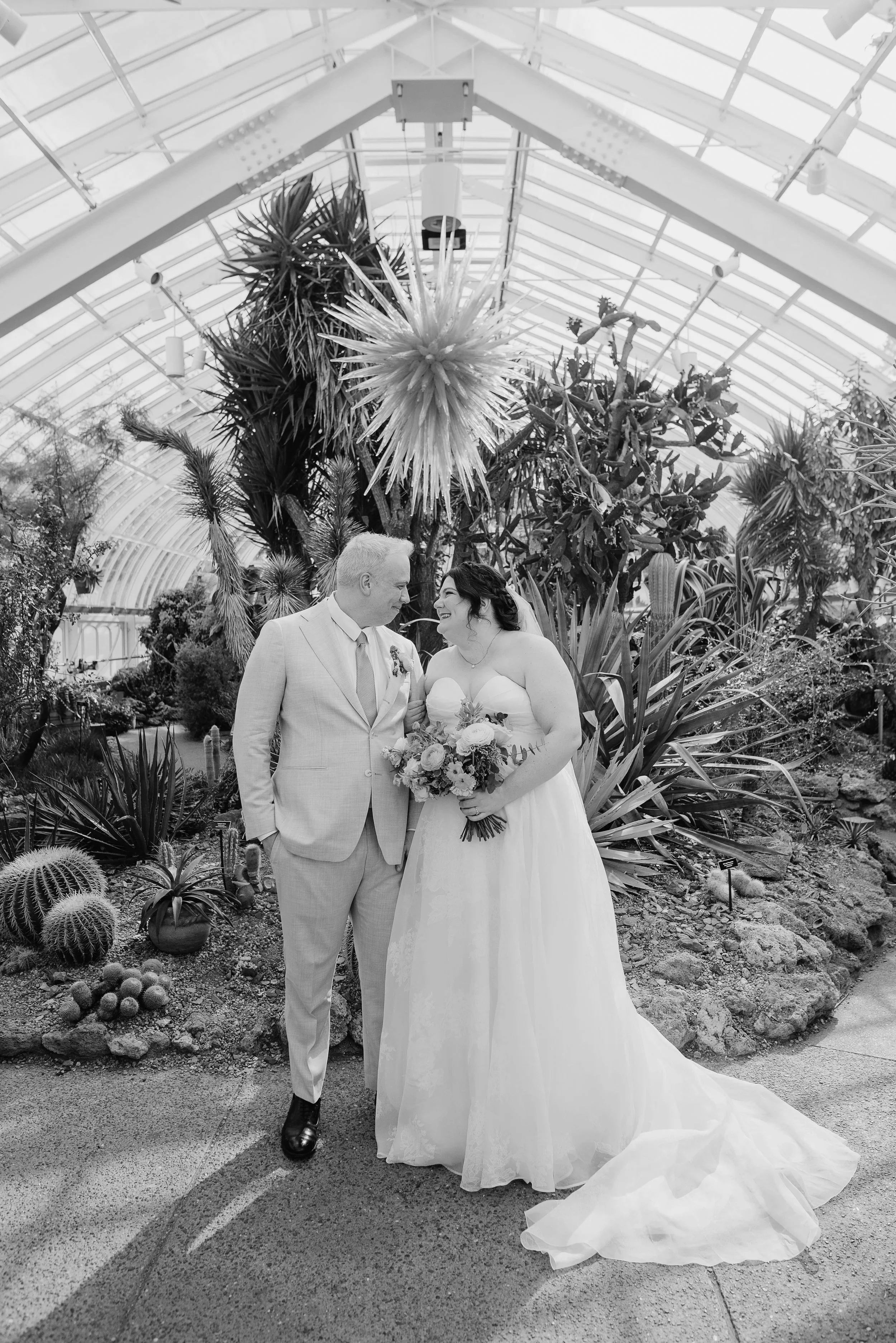 Photo of couple in Phipp's Conservatory in Pittsburgh, showcasing a unique botanical "chandelier". By Jess Vogelsang
