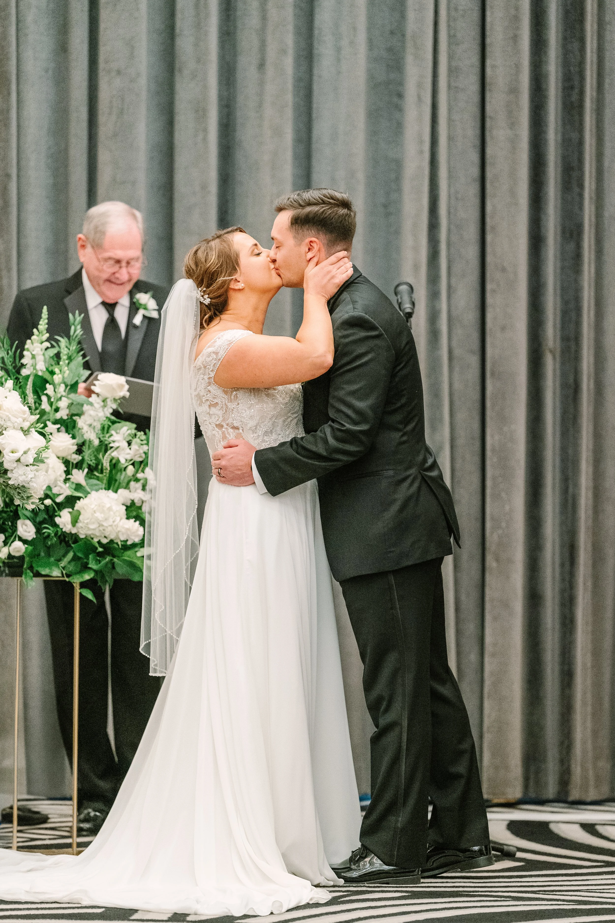 The happy couple, sealing their marriage with a kiss in their ceremony space at Hotel Monaco.
