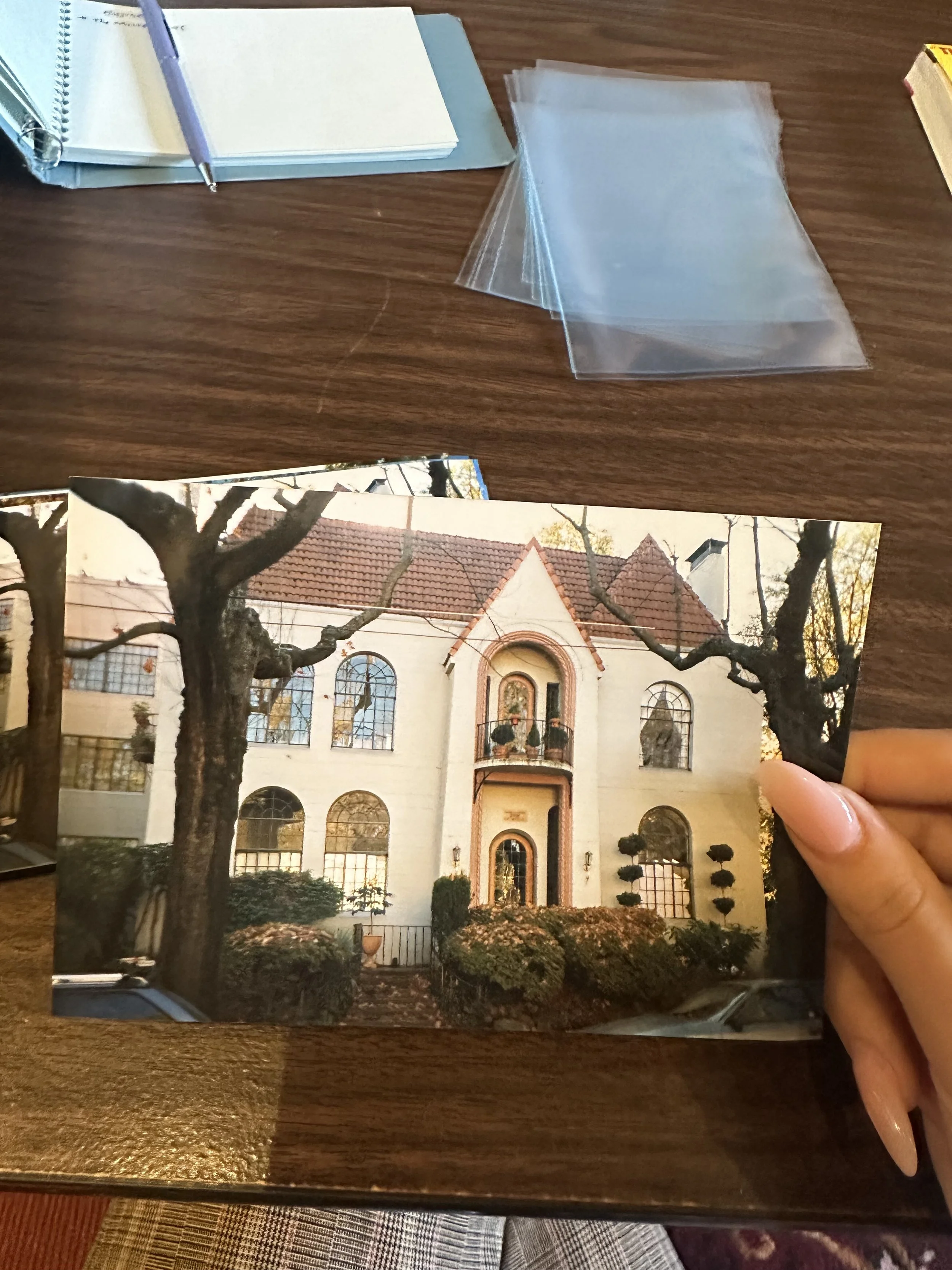 A hand holds a photo of a home featured in the Cornerstones Project.