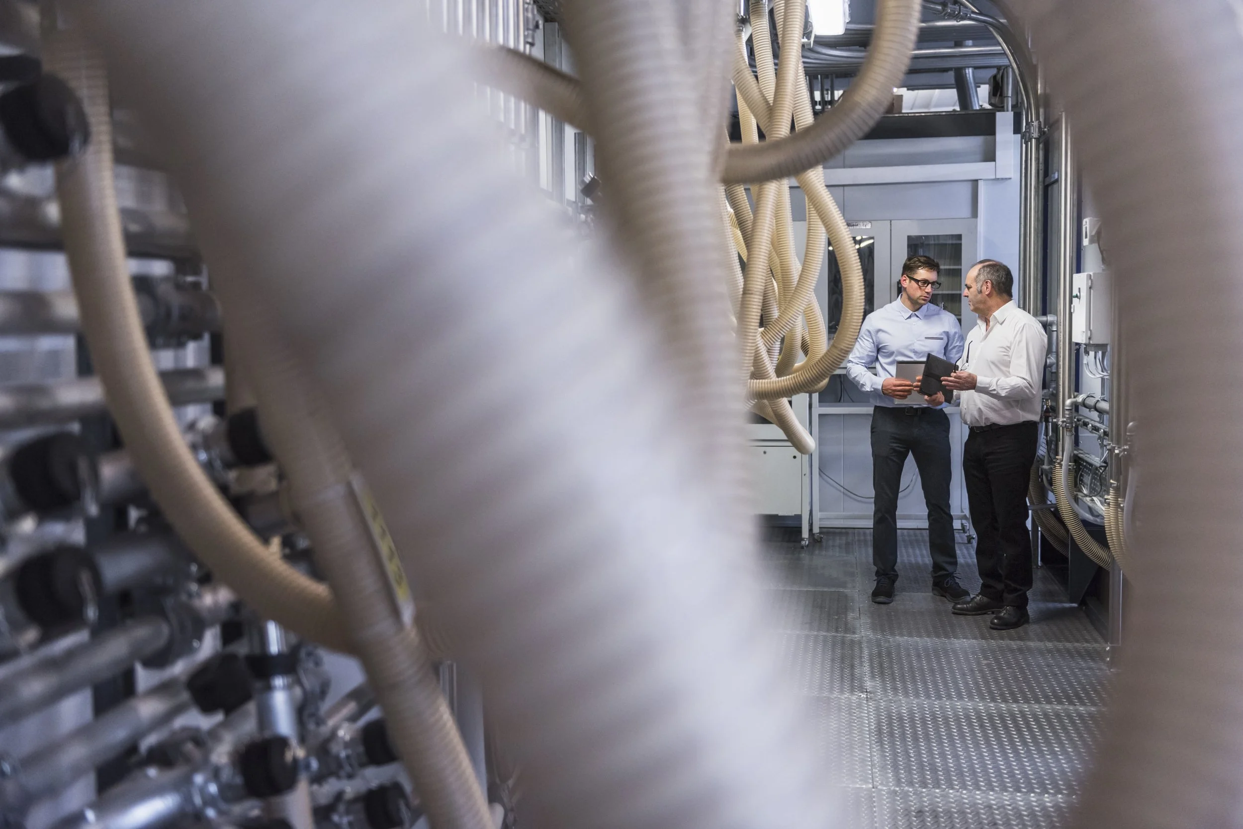 two-men-talking-about-the-system-in-factory-2024-09-15-06-07-44-utc.jpg