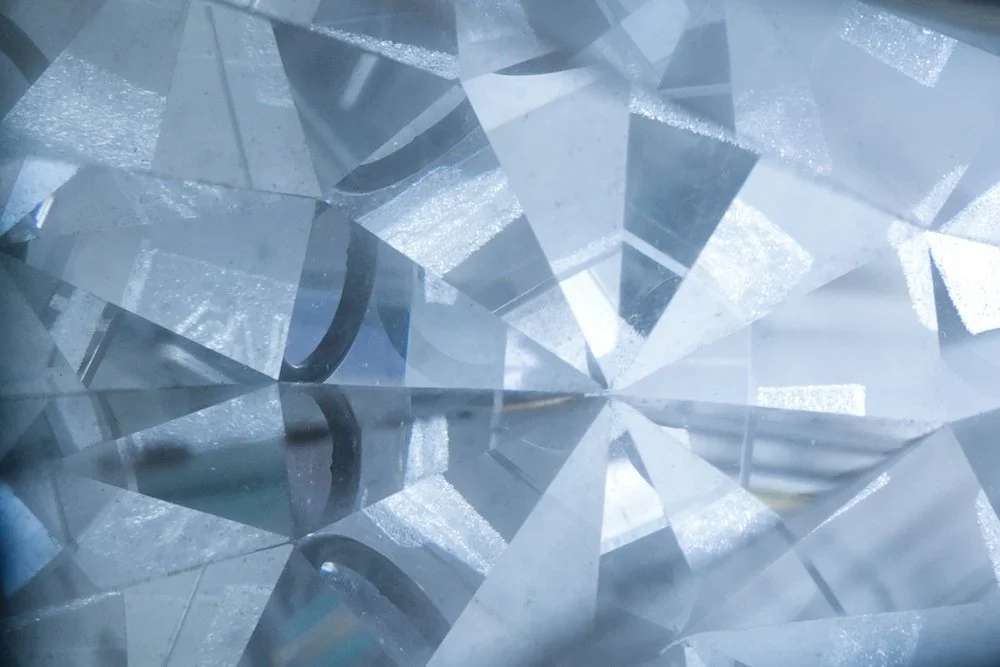 Close-up of a cut diamond showing its faceted surface and internal reflections.