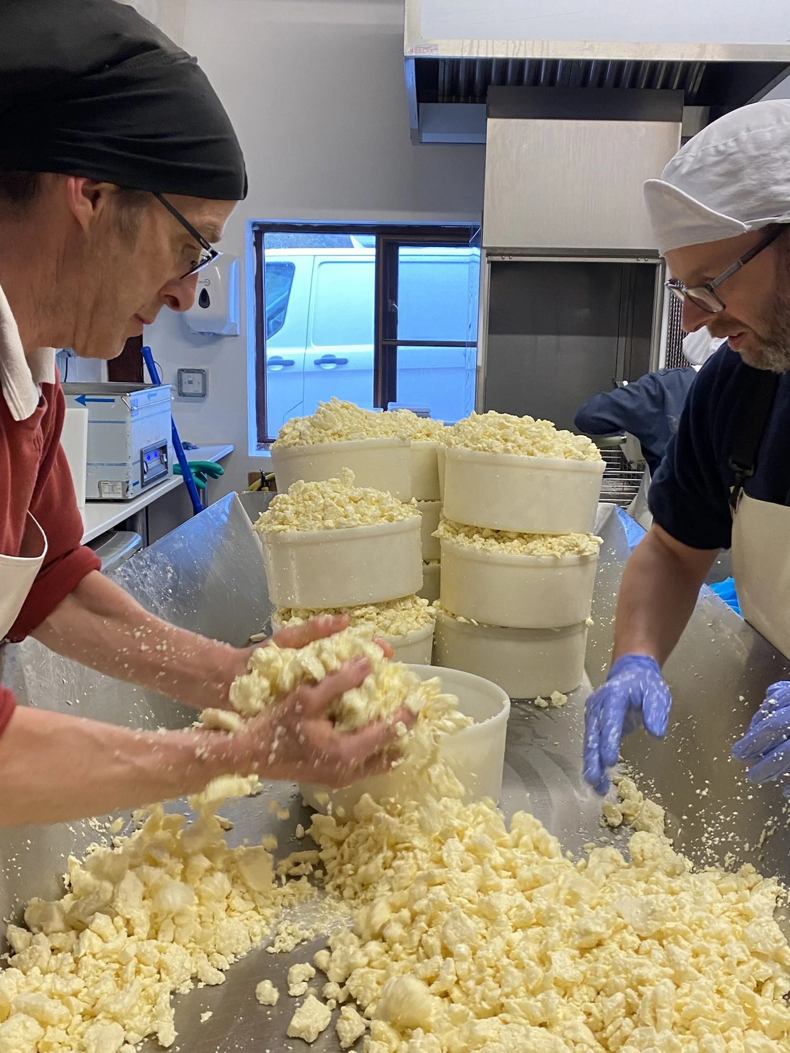 Robert & Dean are filling the cheese molds with milled cheese curds, ahead of the molds being put in the cheese press.