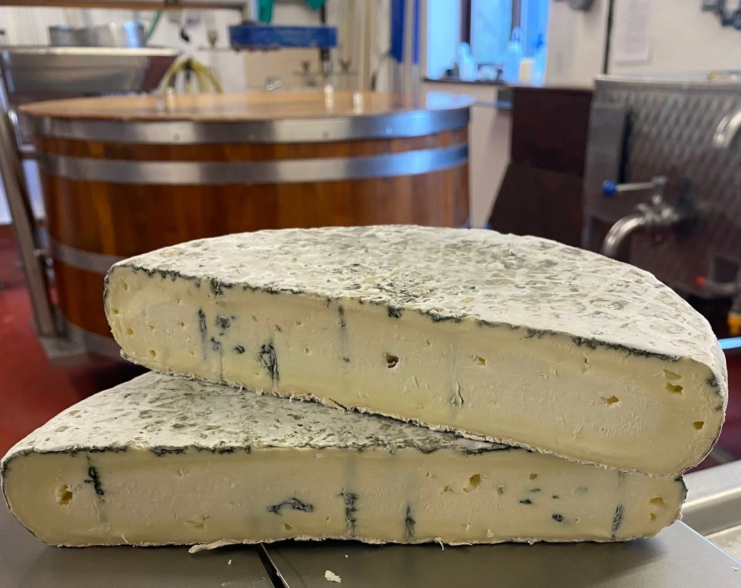 A large blue monk is cut in half, blue veins of mould run through the cheese.