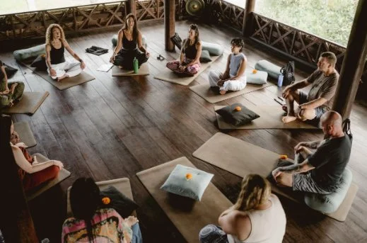 Small group breathing together in a wooden studio
