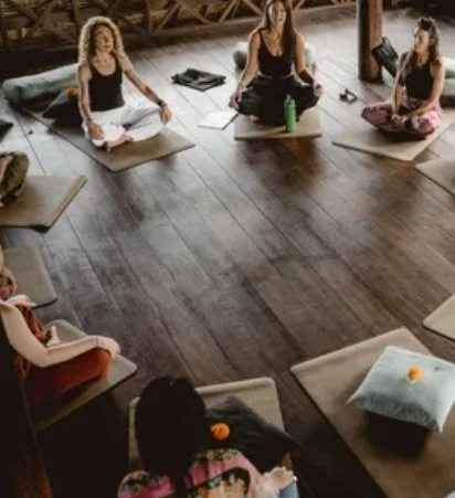Women sitting in a circle on a wooden floor