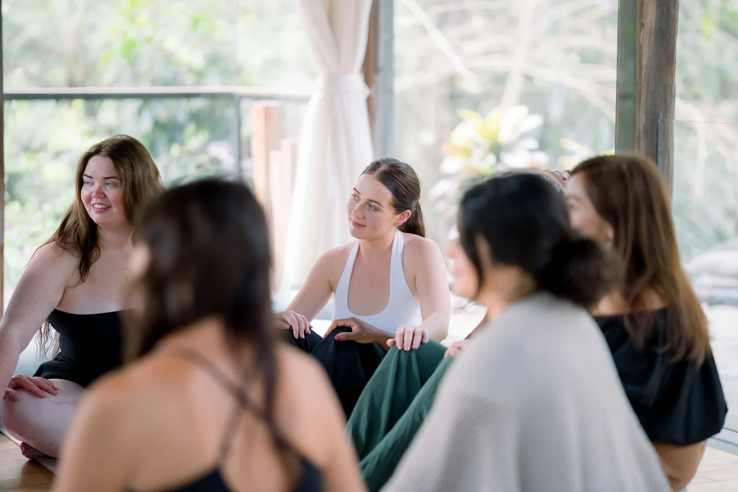 Women sitting together and smiling in an open studio