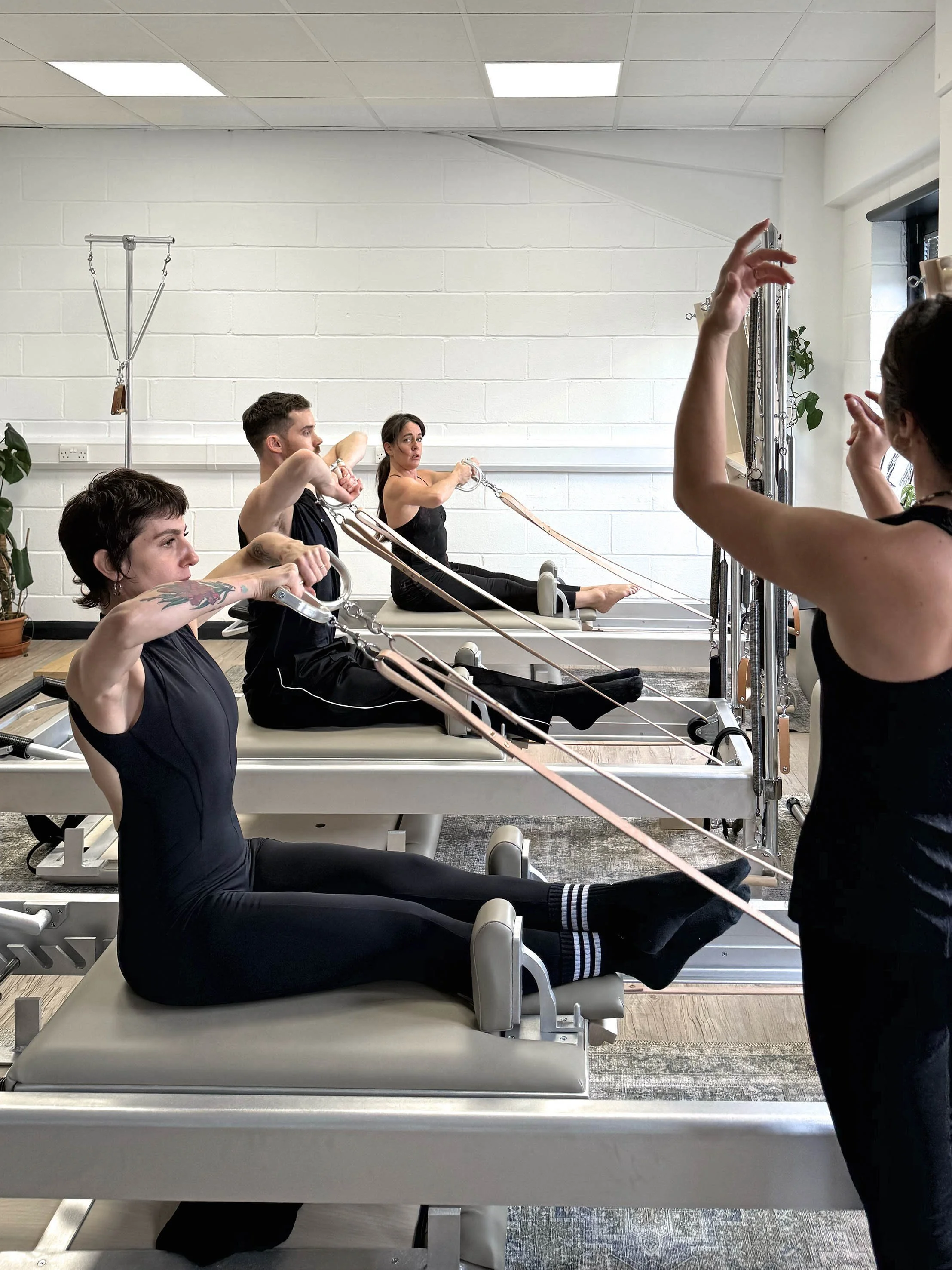 Advanced group class  demonstrating rowing exercise on the reformer