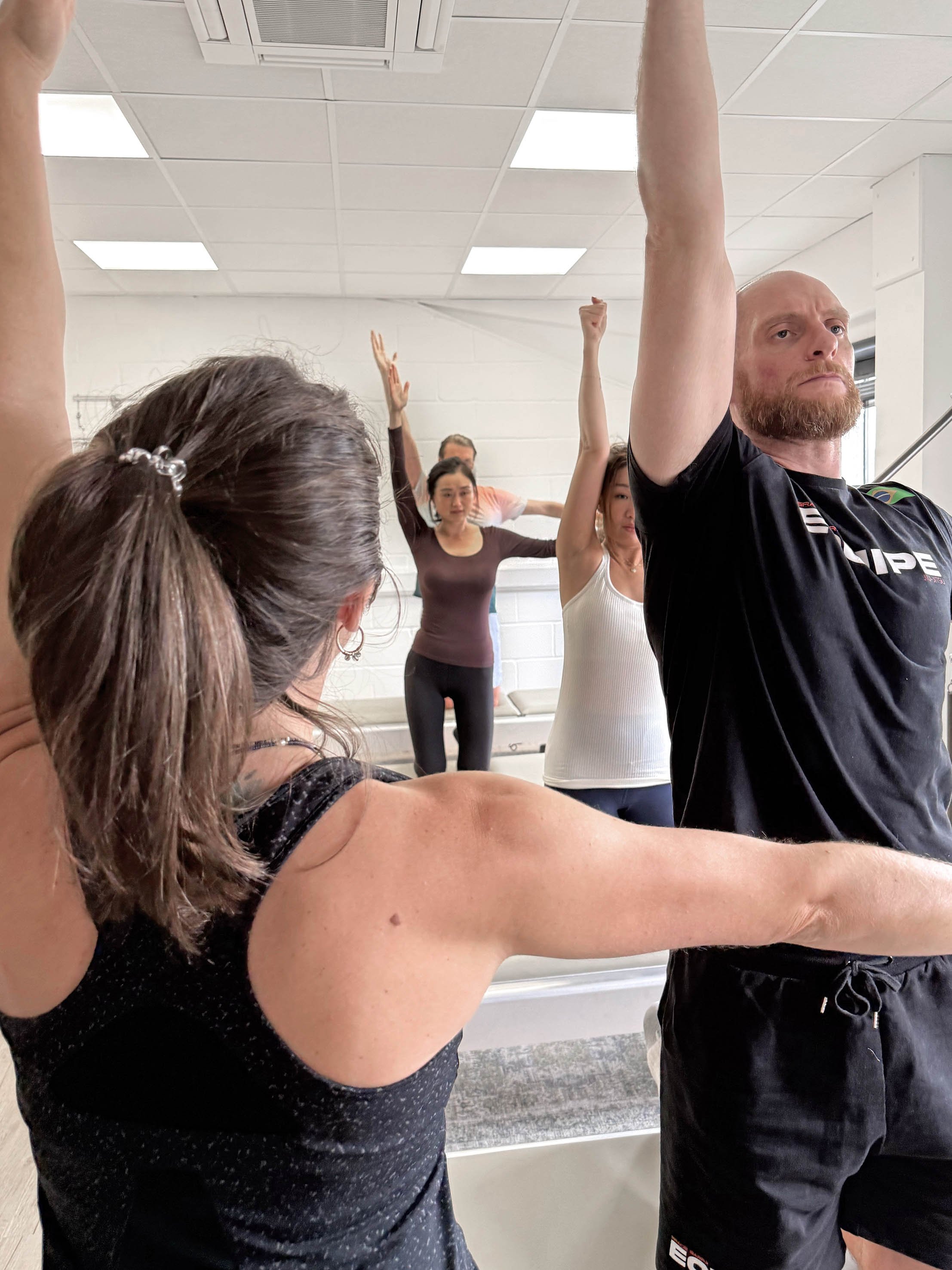 Teacher instructing a group class - side bend exercise on the classical Tower
