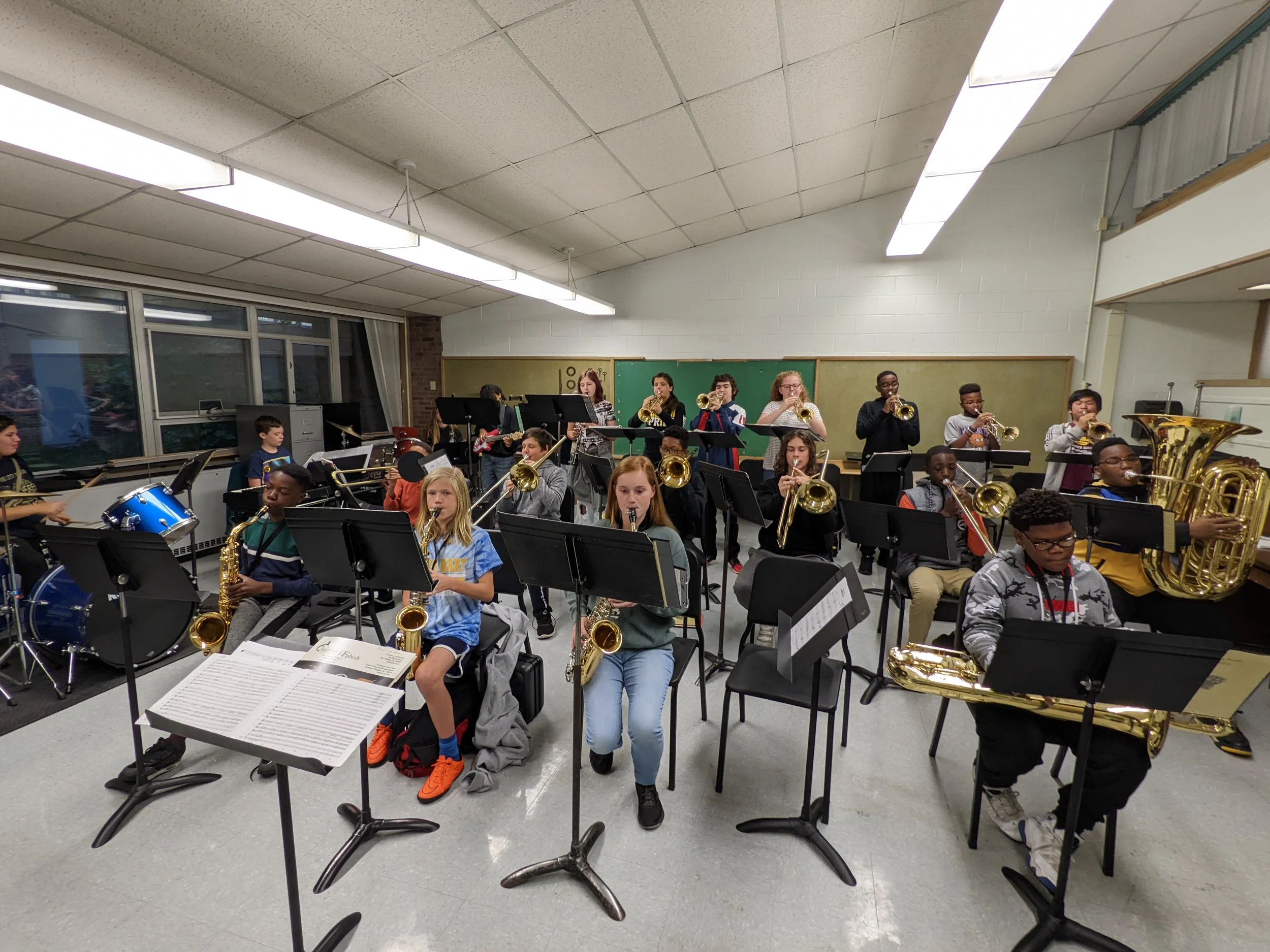 A band ensemble warming up in a classroom before school.