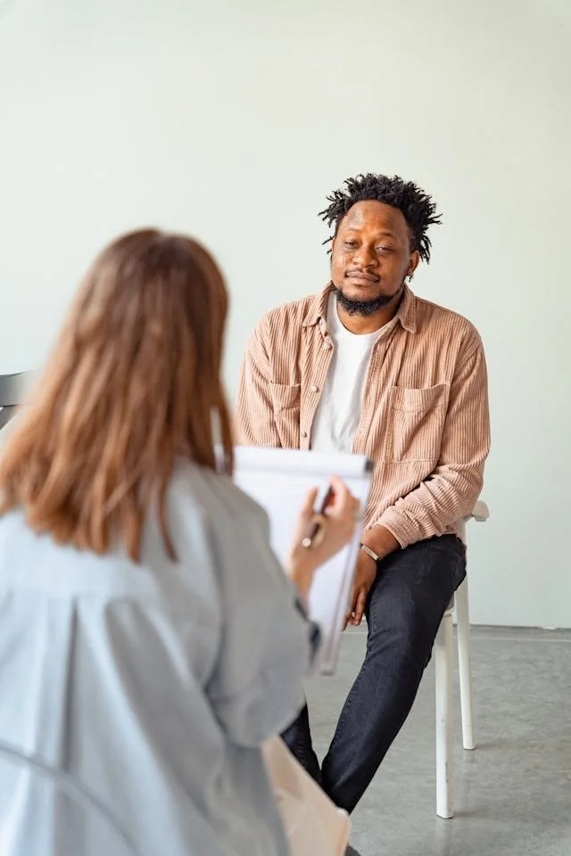 man in pink shirt in therapy session