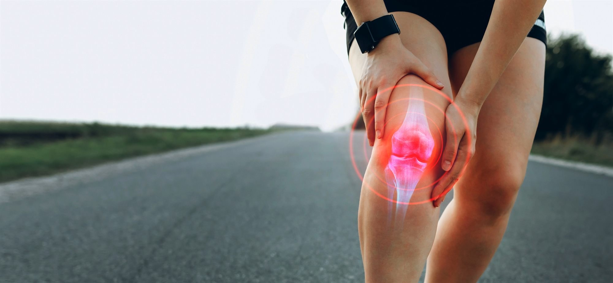Runner holding a painful knee, a warning sign of injury rather than soreness