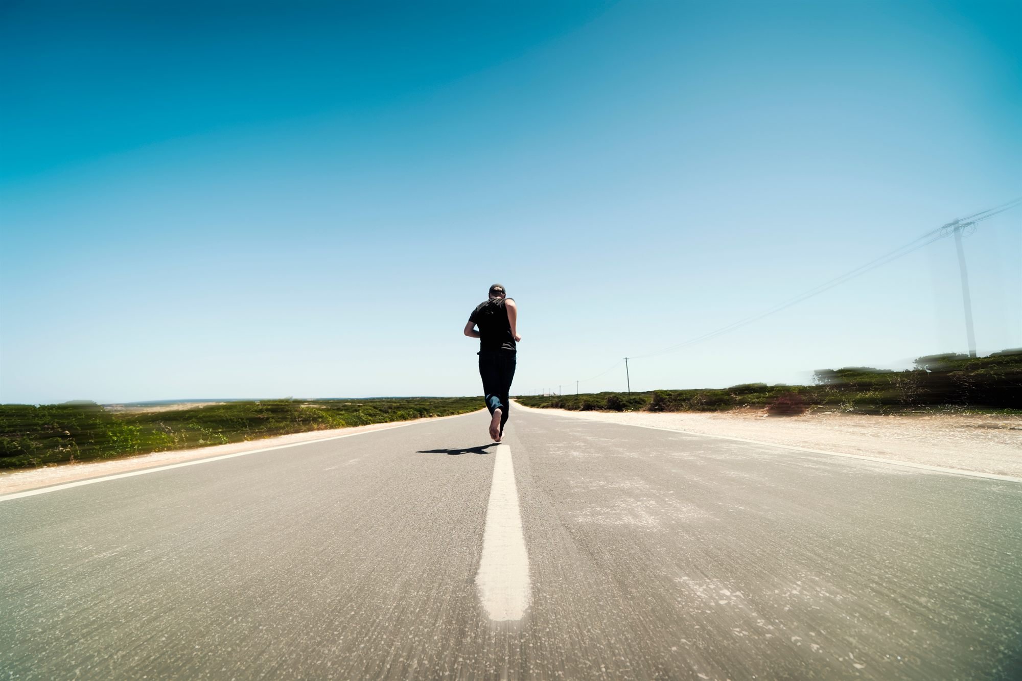 Runner deep into a long training run on a quiet morning road.