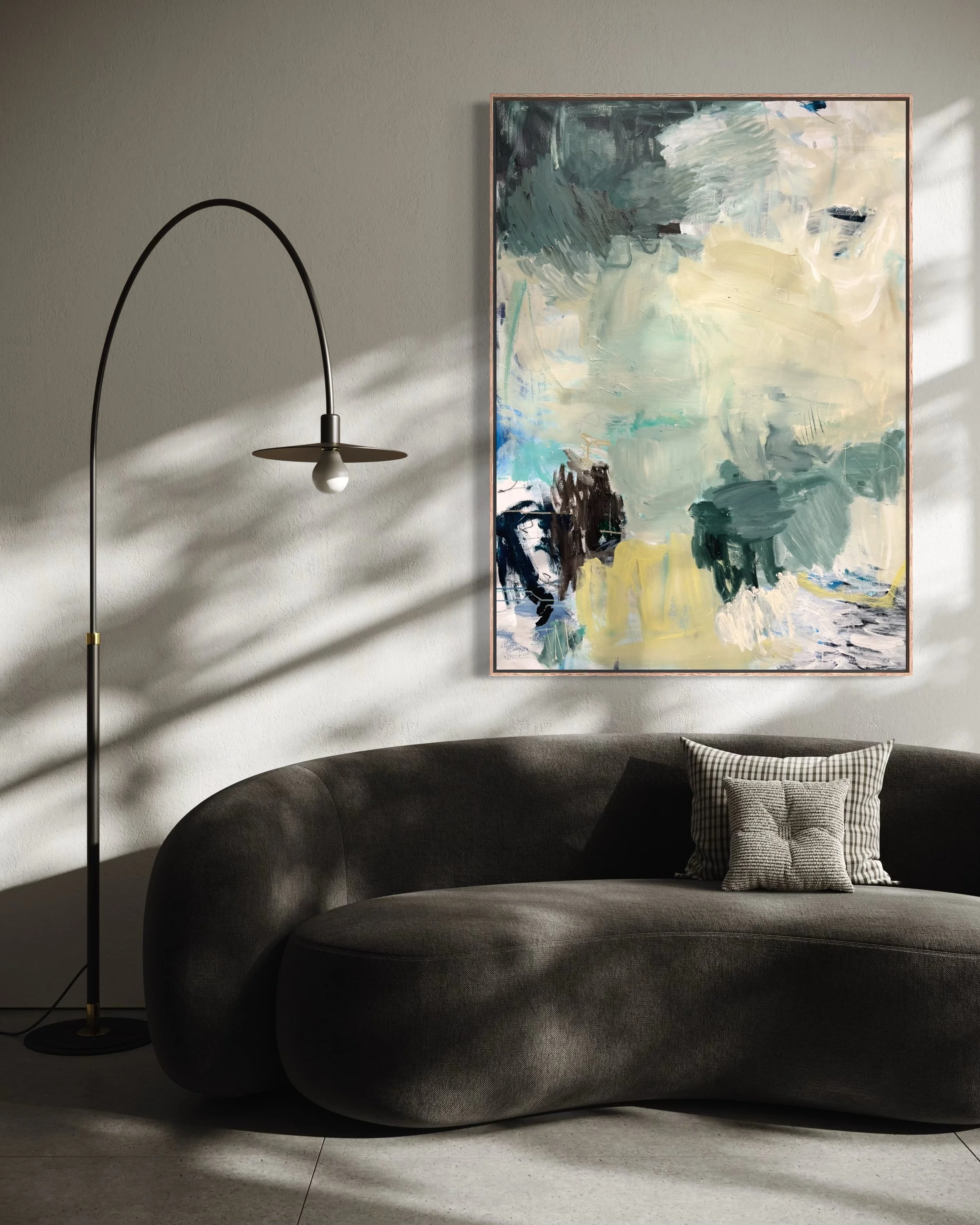 Living room with a dark curved sofa, a patterned throw pillow, a tall black floor lamp with an arched stand, and an abstract painting with shades of green, white, and black on the wall.