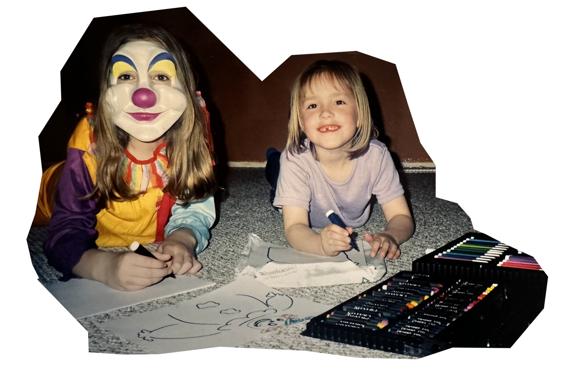 A person dressed as a clown with a painted face and a child sitting on the floor drawing with markers, with drawing supplies and paper in front of them.