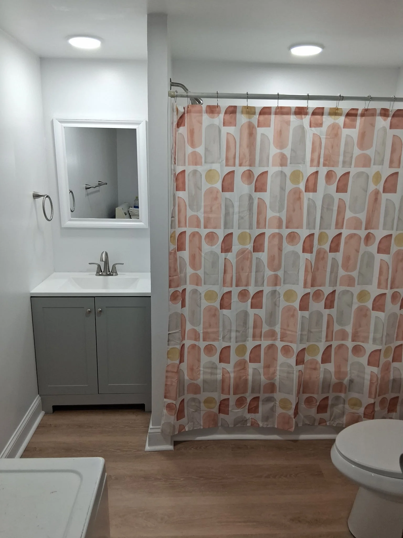 Bathroom remodel in lancaster county featuring a new tub and surround, drywall, exhaust fan, recessed lighting, vanity, toilet, LVP flooring, and trim.