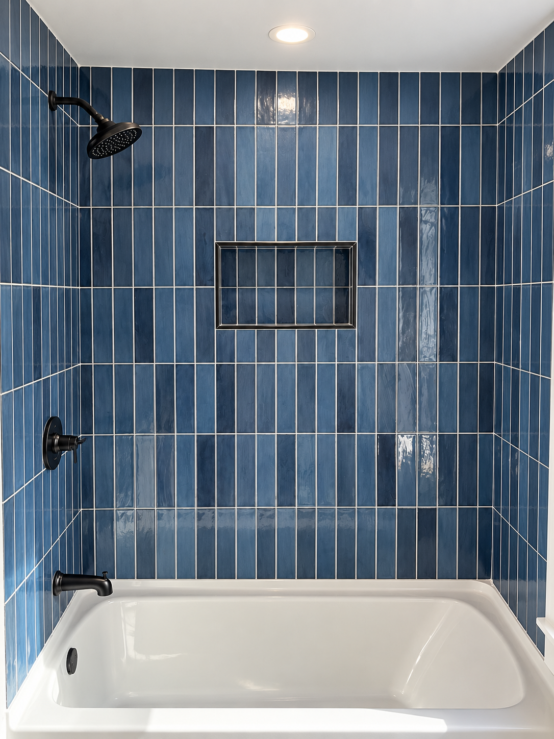 Blue vertical tile tub surround with recessed niche and black fixtures