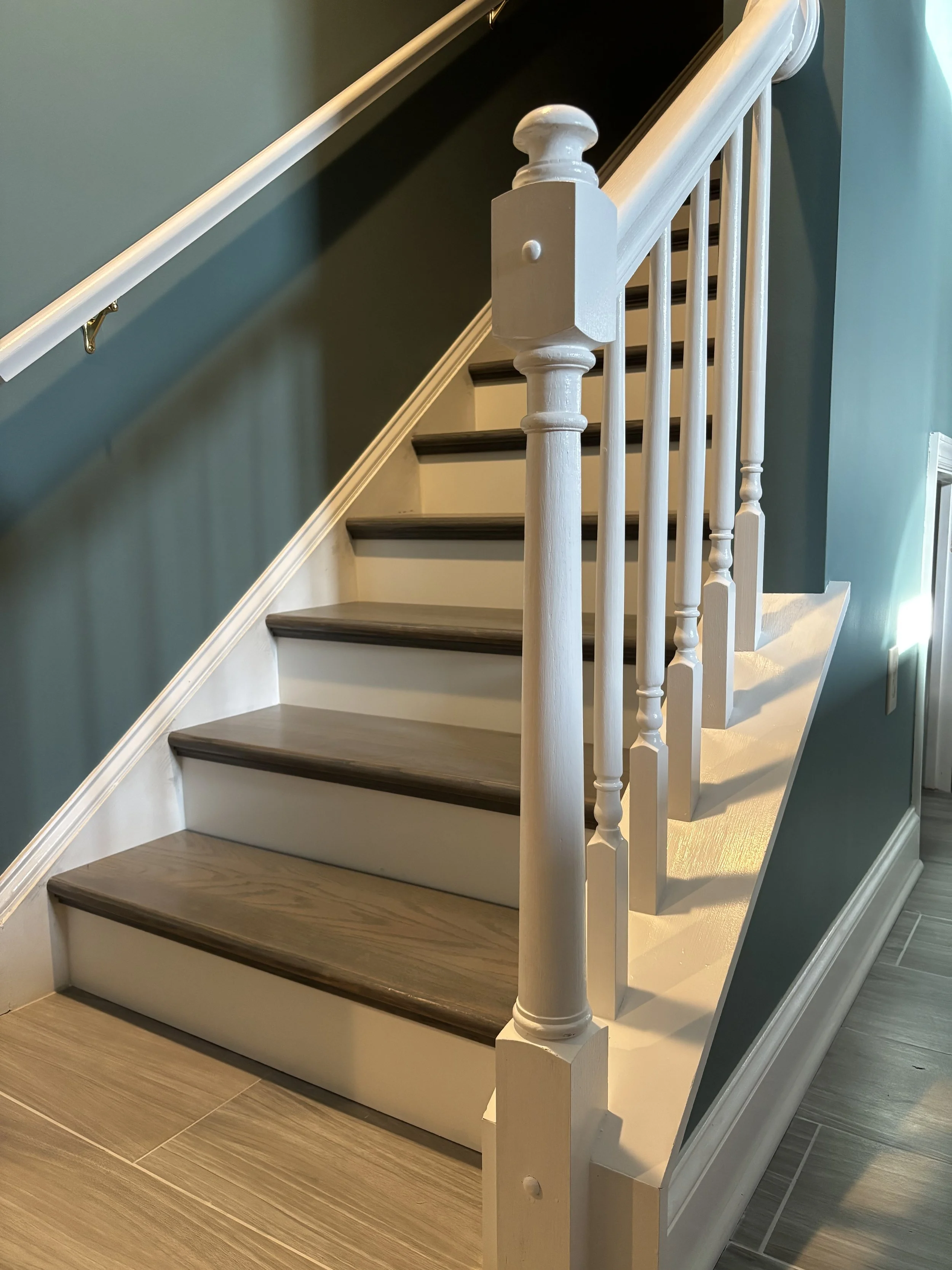 Refinished wooden staircase with stained treads and white risers