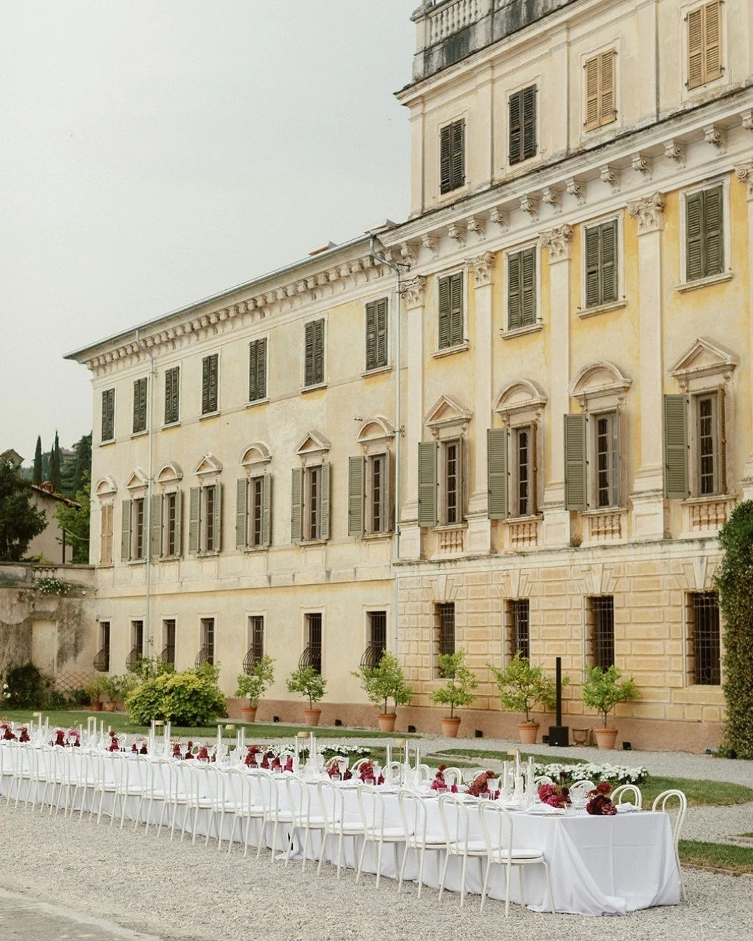 Dreamy dinner table details at Villa Bettoni, set against the historic facade overlooking Lake Garda.
Long tables, crisp linens and deep-toned florals create a sense of quiet luxury &mdash; effortless, elegant and intentionally understated. We are tr