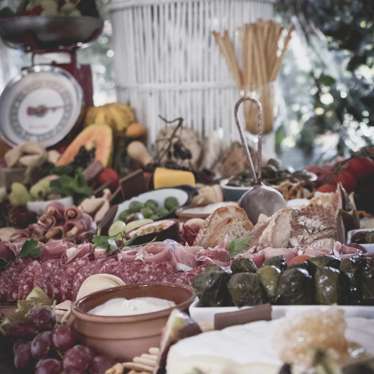 Assorted charcuterie board with meats, cheeses, fruits, vegetables, and bread