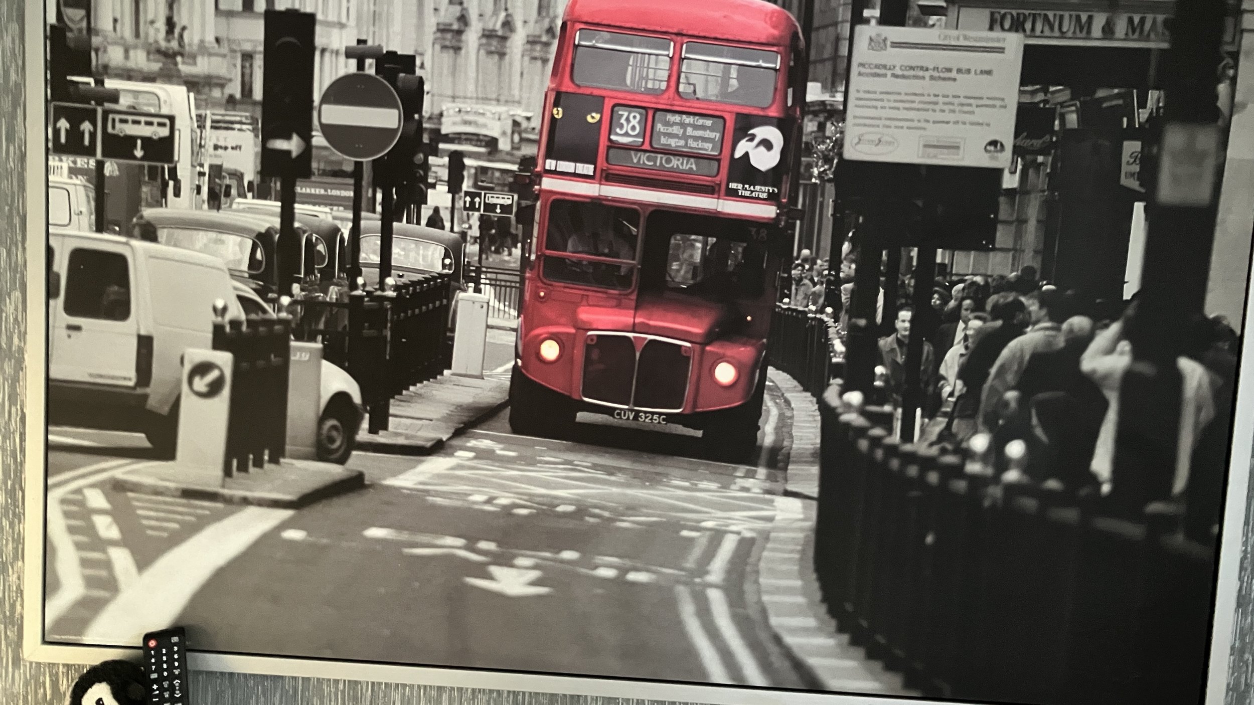 Norman – red bus in monochrome city scene