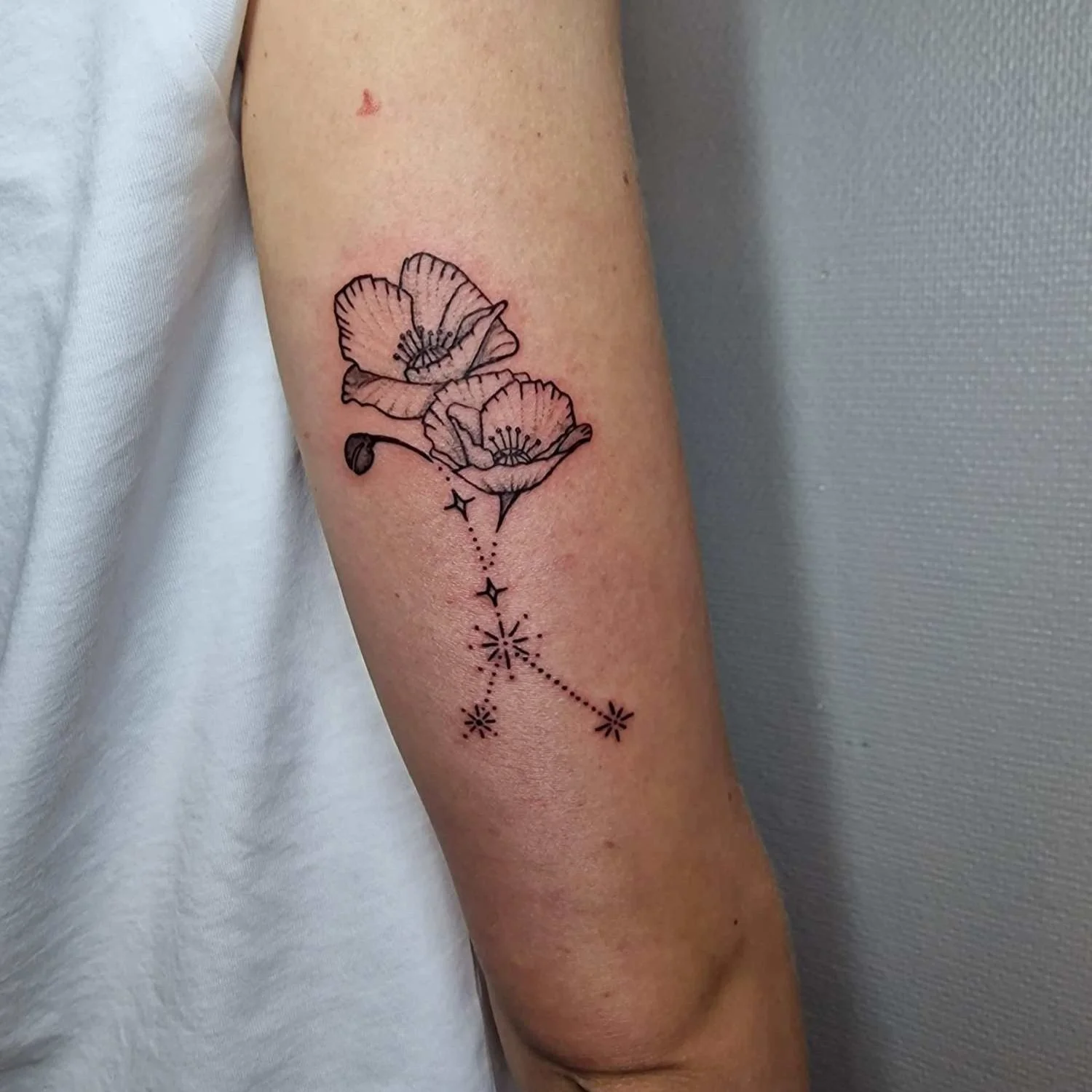 Ravun tähtimerkki ja unikon kukat tatuointi