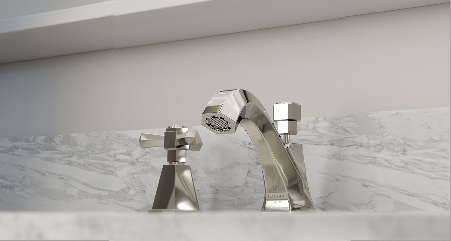 Branded Haddon basin mixer with geometric crosshead taps in polished nickel, set on a honed marble surface – combining heritage design cues with premium British engineering.