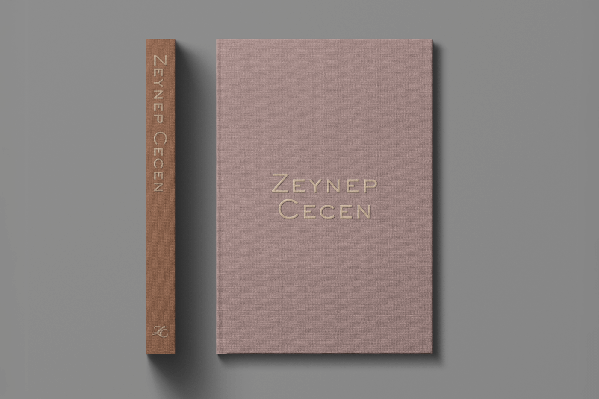 A pink book titled "Zeynep Cecen" with a matching pink cover next to a brown spine with the same name, placed on a gray background.