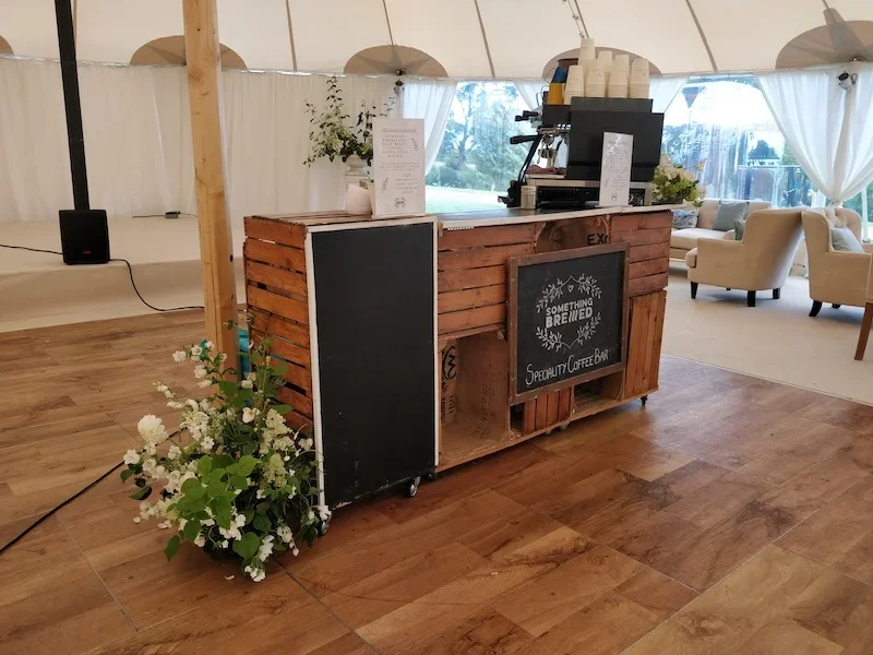 Mobile coffee bar serving wedding guests inside marquee venue
