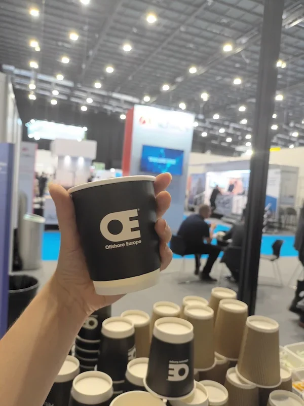 Branded coffee cups displayed at a large exhibition